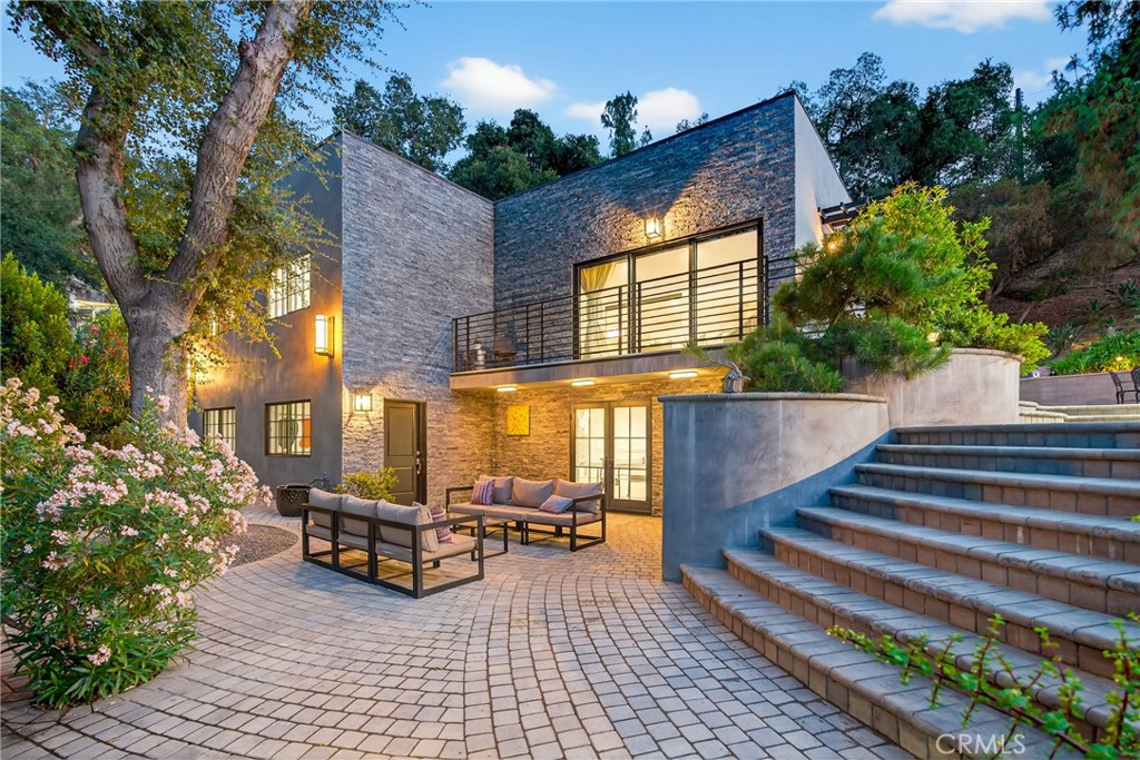 Set on 4.4 acres of beautifully landscaped grounds, this remarkable multi-parcel estate blends modern luxury, artistic design, and serene outdoor living. Three fully remodeled residences are surrounded by lush gardens, mature oaks and cherry blossoms, and sweeping mountain views—offering a rare level of privacy and tranquility.
A Japanese garden by renowned designer Tomoyuki Nakamura serves as the heart of the property, complete with a 12 foot Torii gate, a peaceful picnic area, and a rare imported glass greenhouse. Custom artistic touches and faux bois by Terence Eagon, stonework hardscaping, and a fully irrigated hillside enhance the estate’s distinctive charm.
The main home features 4 bedrooms and 4 bathrooms, thoughtfully renovated in 2023 with porcelain tile floors, Shoji screen closets, a stone fireplace, and a chef’s kitchen with stainless steel appliances and quartz countertops. Fleetwood sliding doors open to garden-view balconies, creating a seamless indoor-outdoor flow. Two additional residences—a 1-bed, 2-bath home and a 3-bed, 2-bath home—offer stylish living spaces for guests or extended family.
Perfectly located next to McGroarty Park with two playgrounds and tennis courts, as well as the McGroarty Arts Center, which hosts vibrant community events and creative classes, this one-of-a-kind property delivers exceptional comfort, artistry, and natural beauty in a private, tranquil setting.