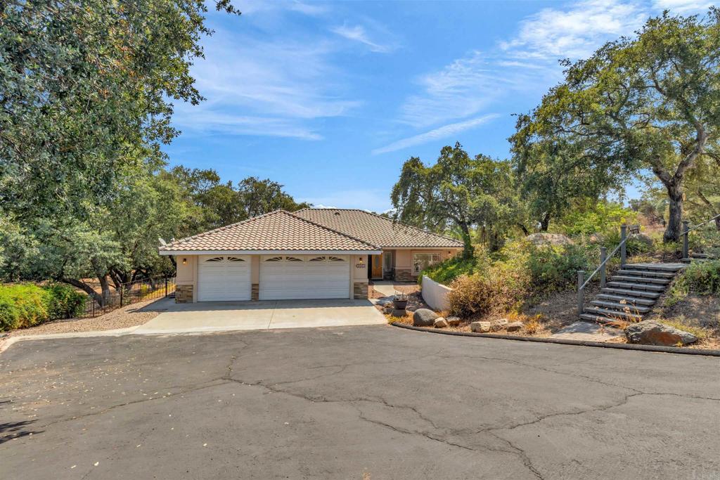 Spacious, SINGLE-STORY ranch style home in a secluded CUL-DE-SAC offers countryside VIEWS and an impressive detached RV STORAGE GARAGE or WORKSHOP in addition to an attached 2 car garage. The paved long roundabout driveway ensures easy maneuvering for large vehicles like a Class A motorhome or fifth-wheel trailer. Besides ample PARKING, this home enjoys natural light and high ceilings throughout. The layout includes a large living room, a den that could be a 4th bedroom, and an open family room with a fireplace. The kitchen is a chef's delight equipped with beautiful granite countertops and woodgrain vinyl floors. Luxurious primary suite is a private retreat with a separate tub and shower, dual sinks, and a walk-in closet. Down the hall there's an indoor laundry room with deep utility sink. The property is thoughtfully designed for outdoor living with ample space for a horse coral, garden, pool, or possibly a guest house or ADU. This custom home is a true gem, combining privacy, functionality, and stunning views.