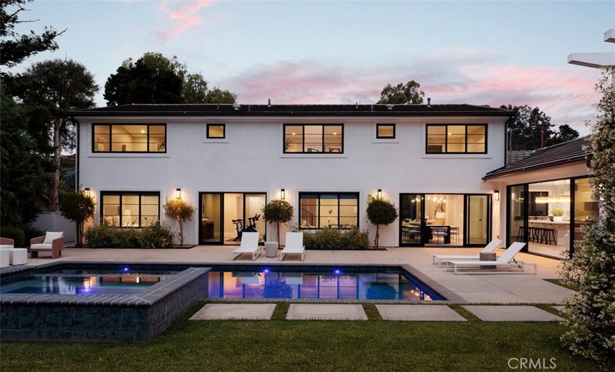 Newly rebuilt in late 2022 from the studs out and completely reimagined and expanded, this fabulous new home in Villa Park is truly unparalleled. Move-in ready, the residence offers the rare and enviable combination of newer construction in an established neighborhood, with mature landscaping and a prime corner homesite of about .46 acres adding to its undeniable appeal. Bathed in natural light that shines through an abundance of large windows, the open design showcases a foyer and living room with double-height ceilings, a contemporary staircase and a lofty interior balcony above. The grand dining room is certain to be a favorite place to share memorable occasions, and it opens to the backyard, creating a seamless indoor/outdoor vibe. Equally open and stylish, the on-trend kitchen displays white Shaker cabinetry, a large island with bar seating, quartz countertops, subway tile backsplash, a stainless steel pro-caliber range, and a built-in cabinet-matched refrigerator. The kitchen flows effortlessly to a family room that is distinguished by a high ceiling, backyard access, and a stone fireplace flanked by custom built-in shelving and cabinetry. Sophisticated and modern, the home’s aesthetic is embellished with warm white and gray hues, wood-plank flooring and chic LED lighting. Five bedrooms plus office/gym and four and a half baths are featured in approximately 4,005 square feet, including ensuite bedrooms, a main-level bedroom, an office, and an upscale-modern primary suite with a vaulted ceiling, freestanding tub, separate shower and two sinks. Grounds are impeccable, with low-water plantings, a tranquil pathway, and an attached three-car garage with a large paver-finished driveway in the front yard. The rear yard reveals a brand-new pool and spa, a large patio, verdant lawn, a lower level with fragrant orange trees, and a beautiful pavilion with a built-in BBQ bar. Excellent schools serving K-12 are nearby, and parks, shopping centers, trails, and restaurants are close to home.
