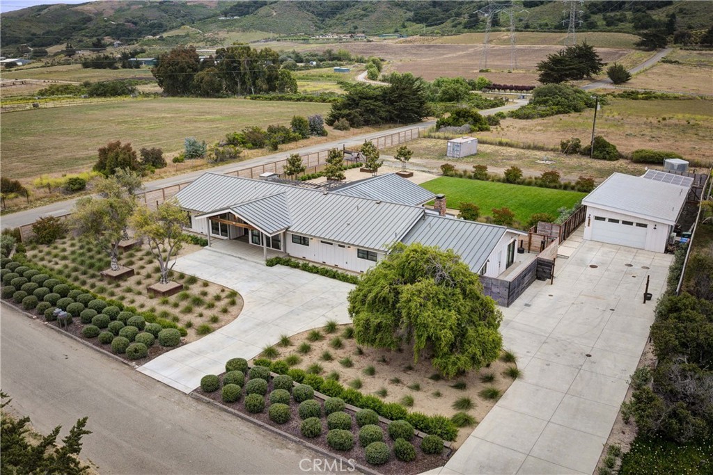 Perched on 1.12 acres with commanding views of Hollister Peak and the rolling valley hills, 2289 Falcon Ridge is a modern farmhouse estate designed for those who value both beauty and versatility. Extensively remodeled in 2020 with enduring style and quality in mind, the property blends contemporary finishes with timeless character in a setting that feels private, expansive, and connected to the land. The grounds are carefully planned to capture the essence of relaxed California living. Custom patios extend seamlessly from the home, offering spaces for dining, lounging, and stargazing beside the fire pit. Olive trees in handcrafted planters, mature magnolias, and fruiting guava bring life and color to the landscape.
Beyond the main residence, the estate includes a private entry 1 bedroom guest suite and a detached two-bedroom, two-bath residence complete with a full kitchen, two-car garage, and private yard. Whether envisioned as guest accommodations, multigenerational living, or long-term rental opportunity, these spaces extend the flexibility of the property without compromising privacy. The property features owned solar, a private well, durable cement-fiber siding, custom vertical fir windows, and an insulated metal roof ensuring lasting appeal, while modern fixtures and finishes add sophistication throughout. Nestled in the Los Osos Valley, two miles off the ocean with a cool breeze at night and sunny days out of the coast fog. 2289 Falcon Ridge is more than a home - it is a lifestyle estate that captures the spirit of California’s Central Coast, where modern amenities, natural beauty, and versatile living come together in one exceptional property.
