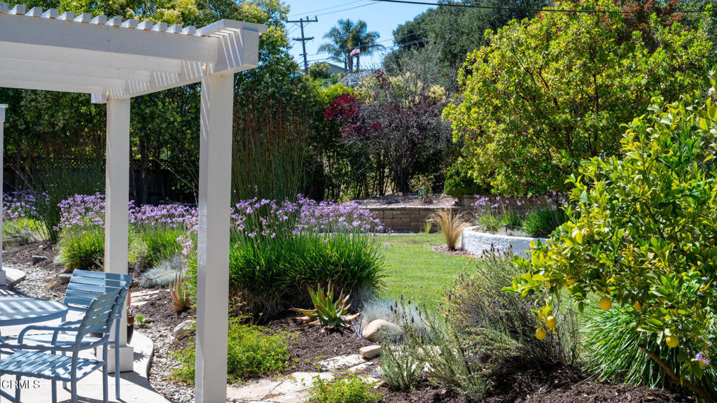 Mountain Views & Magical Backyard. Set on a beautifully landscaped 0.40+/- acre parcel, this 3 bedroom, 2 bath home offers 2,108+/- sq. ft. of comfortable living space and a wonderful blend of indoor-outdoor charm. Throughout the home, travertine tile flooring adds timeless elegance and durability, complementing the bright living room with its wood stove, abundant natural light, and French doors that open to a spacious deck with serene mountain views. The kitchen features granite countertops, stainless steel appliances, a wine fridge, and bar seating-perfect for casual dining or entertaining. A separate family room with a fireplace and sliding glass doors provides easy access to the lush backyard. The primary suite includes an office area, a walk-in closet, a large walk-in shower, and a soaking tub for ultimate relaxation. Out back, the trellised patio opens to a magical, park-like setting with lush lawns, citrus + fruit trees, and a peaceful sitting area tucked beneath a beautiful pepper tree-an ideal space to unwind or host guests. With a covered front porch, 2-car garage, and serene surroundings, this home offers the perfect retreat in the heart of the Santa Ynez Valley--close to Solvang's shops, dining, and wine tasting, yet feeling wonderfully tucked away.