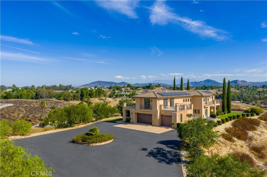 Stunning custom-built estate in the heart of Temecula wine country! Built in 2012, this impressive 5-bed, 4-bath home offers approx. 5,088 sq.ft. of elegant living space on a private 5.5-acre lot. A gated driveway leads to a peaceful retreat with sweeping vineyard and hill views. The open floor plan features soaring ceilings, a chef’s kitchen with premium appliances, formal dining, and multiple living areas. The luxurious primary suite has a spa-inspired bath, walk-in closets, and a private balcony. Outdoor spaces include expansive patios, landscaped grounds, and plenty of usable land for horses, vineyards, or future guest house/ADU — ideal for both personal living and investment potential. A 3-car garage plus ample parking. Close to wineries, dining, shopping, and freeway access — privacy and convenience in one exceptional property.