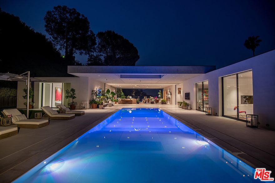 PROPERTY OFFERED FULLY FURNISHED. Warm Modern Masterpiece set on an over 31,000 sq.ft. lot in prime lower Trousdale Estates w/beautiful city views. Built in 2016, this property offers epic scale w/high ceilings, open spaces & walls of glass that disappear & blur the lines between the indoor & outdoor spaces. Situated behind private & discrete gates leading to the large motorcourt & impressive floating entrance w/water features & pivot front door. Enter into the voluminous main gallery connecting the various public rooms. Designed for large scale entertaining, the vast living rm flows to the outdoor living rm & zero edge infinity pool. Formal dining rm, state-of-the-art kitchen, secondary catering kitchen & family rm w/glass enclosed temperate-controlled wine display. The master suite features beautiful city views, incredible walk-in closets & spectacular bath. 4 add'l bdrm suites each w/walls of glass opening to the grounds & staff quarters.