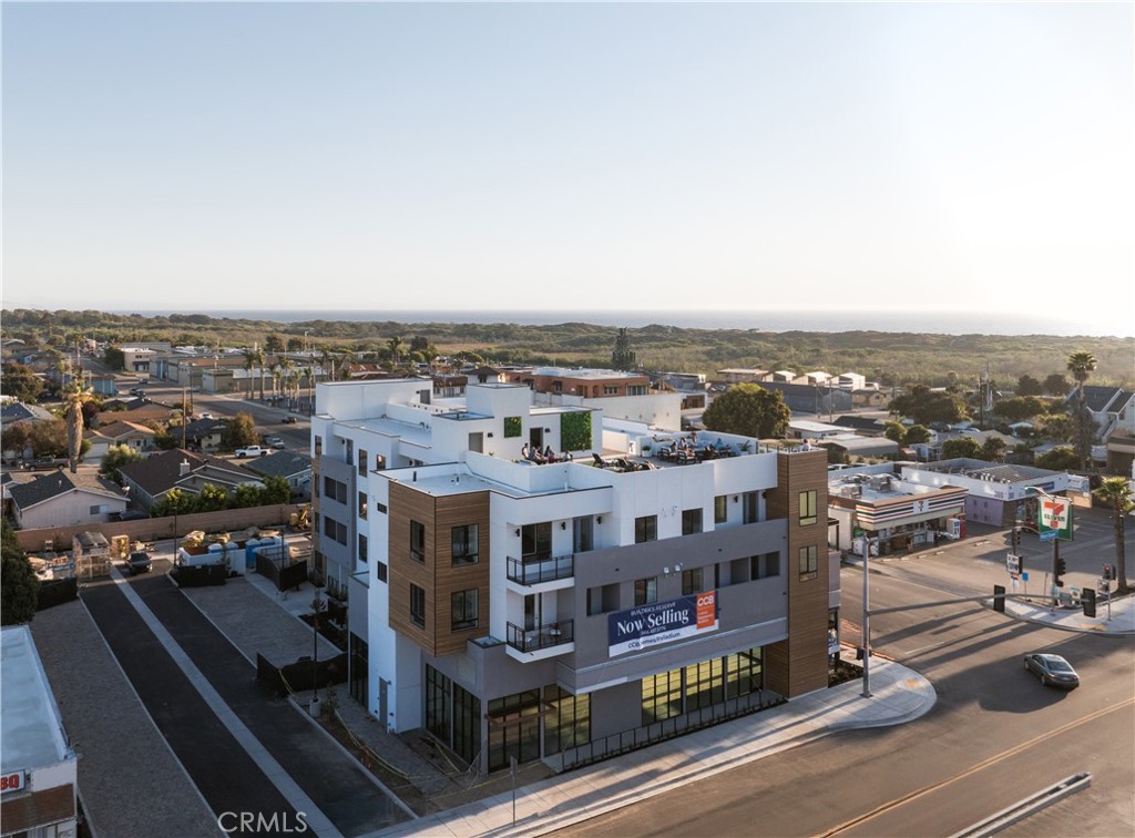 BRAND NEW CONSTRUCTION CONDO - MOVE IN READY!
Located just blocks from the beach and in the heart of the West End, Unit 101 offers brand-new construction, modern finishes, and access to a stunning rooftop deck with panoramic views of the ocean, dunes, Port San Luis, and Arroyo Grande Valley.
This one-bedroom, one-bathroom corner unit condo features an open layout with quartz countertops, dark-stained soft-close cabinetry, and stainless steel appliances—including a new refrigerator and stackable washer/dryer. The bathroom includes a roll-in frameless glass shower with full-height quartz walls and a marble hex tile floor. Luxury vinyl plank flooring runs throughout, with tile in the bathroom. Matte black fixtures and large windows enhance the clean, modern design. This corner unit is west-facing and is light and bright and a few short blocks to the beach.
A patio extends the living space outdoors, and a mini split HVAC system provides efficient heating and cooling. The secured building includes a lobby and elevator.
