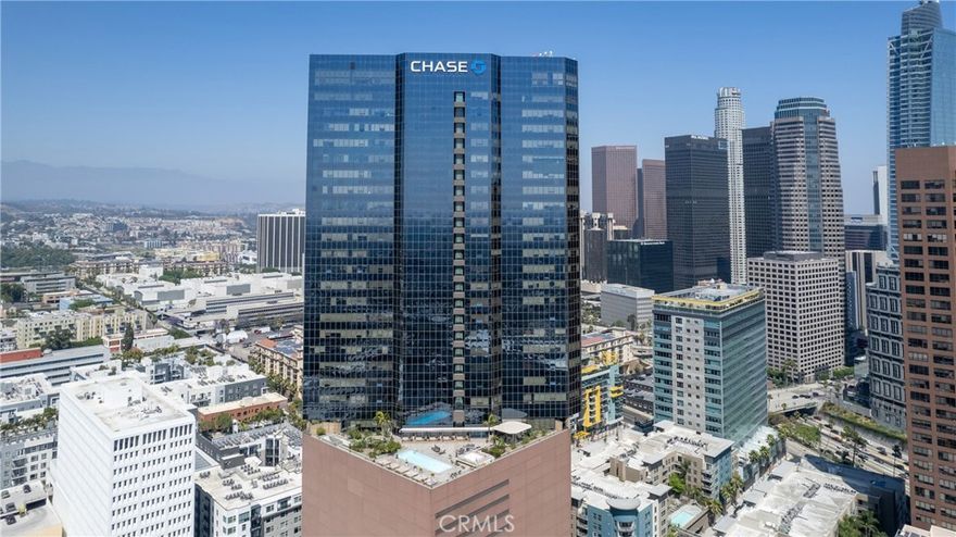 A rare corner loft suite on the 22nd floor offering sweeping southwest facing panoramic views of the Downtown LA skyline, LA Live, the Westside, and the resort style sky deck with pool. The flexible den functions perfectly as a breakfast nook or home office. The modern European style kitchen features upgraded appliances, granite countertops, and elegant cabinetry, complemented by wood floors throughout. A glass partition subtly separates the living and sleeping areas while maintaining an open airy loft feel. Additional highlights include an in unit LG washer and dryer, a spacious bathroom with storage, and two side by side parking spaces. Residents enjoy resort quality amenities, including a 17th floor sky deck with a heated infinity pool, spa, cabanas, lounge beds, wet bar, BBQ grills, and a fire pit lounge area. The building also offers a fully equipped fitness center, media and screening room, business center, and 24 hour concierge, security, and on site management. Located just moments from LA Live, Crypto.com Arena, the Convention Center, public transit, restaurants, and major freeways, this corner unit combines exceptional design, bright and open living, and the very best of downtown lifestyle.