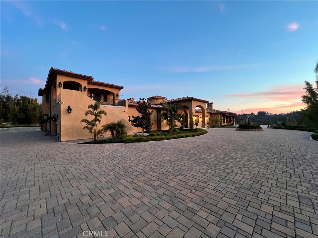 Please note that the above-referenced price reflects the Reserve Price for the property, which is available for purchase through a luxury bidding opportunity. Submit offers now. Seller reserves the right to accept or reject offers and additional terms apply. Please visit Paramount Realty USA’s website for more details. SINGLE-STORY & GUEST UNIT, NEW CONSTRUCTION completed in 2023. Meticulously designed combining luxury by a renowned Feng Shui master to ensure harmony & ample natural light, every detail has been tailored to create an elegant living space on this RARE ELEVATED 2.23 acres with coastal breezes. Entering the PRIVATE double Gates, youre captivated in serenity & privacy, setting the stage for a remarkable living experience. The hand-forged iron double doors entrance welcomes you into a space adorned with Italian Carrara white marble floors & handcrafted wood panels. Platinum iron arched rails & natural Ashlar marble columns enhance the flow of energy throughout the home. The living spaces are bathed in natural light through the stained glass skylights & arched windows, infusing each room with positive chi. Czech crystal chandeliers & intricate wood carvings add a touch of opulence, while custom cherry wood cabinets provide both functionality & beauty. The formal living room with a marble fireplace, surrounded by marble walls that radiate warmth & luxury. The primary suite boasts a marble fireplace, wool carpet, sauna, two bathrooms & two walk-in closets. Entertaining in the family room & bar/wine cellar, Italian marble floors, creates an atmosphere of sophistication & conviviality. The gourmet kitchen with Italian marble floors, cherry wood cabinets, & state-of-the-art Miele appliances, is a chef's dream. The second-story guest unit is attached to the single-story main residence offers its own private entrance with two bedrooms, two bathrooms, kitchen, living room, laundry room & two decks. Outdoor amenities include a BBQ kitchen area perfect for al fresco dining. Highly rated schools, golf, race track & nearby coast, this property stands as a testament to the art of living well in modern luxury. Property offers the opportunity to build an Accessory Dwelling Unit. Pool, garages/unit, primary bedroom, hallway, living room & office images are conceptual intended to illustrate potential ideas & are not to scale. Relevant entities approval are required. Pool blueprints available to preview. Sold furnished with exempted items.
