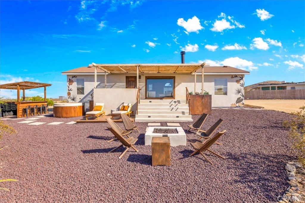 Charm is an understatement. Tucked away on 2 private acres in North Joshua Tree, this fully renovated home offers the perfect blend of style, comfort, and desert seclusion. Surrounded by a complete fence line, the property is designed with magazine-worthy taste and a Santa Barbara–inspired “smooth stucco” finish that immediately sets it apart.
Step inside the gates and you’ll find a thoughtfully curated outdoor experience with an ornate concrete deck, gas fireplace, cedar hot tub, outdoor soaking tub, and a shaded front porch for relaxing desert evenings. Inside, the 3-bedroom, 2-bathroom, 1,248 sq. ft. home has been finished with hand-picked furnishings that complement the clean and modern interior. A cozy gas fireplace warms the home in the winter, while central AC keeps it cool through the summer.
Currently operating as a successful Airbnb, the property is being sold fully furnished, making it turnkey for full-time living or continuing as a high-performing short-term rental. Bay windows invite the sunrise and sunset indoors, while tasteful design details ensure every corner is welcoming and unique. Additional features include city water, propane, leased solar (locked at just $92/month until 2036), and a storage shed for convenience.
A true Joshua Tree gem, this one is ready to enjoy from day one.