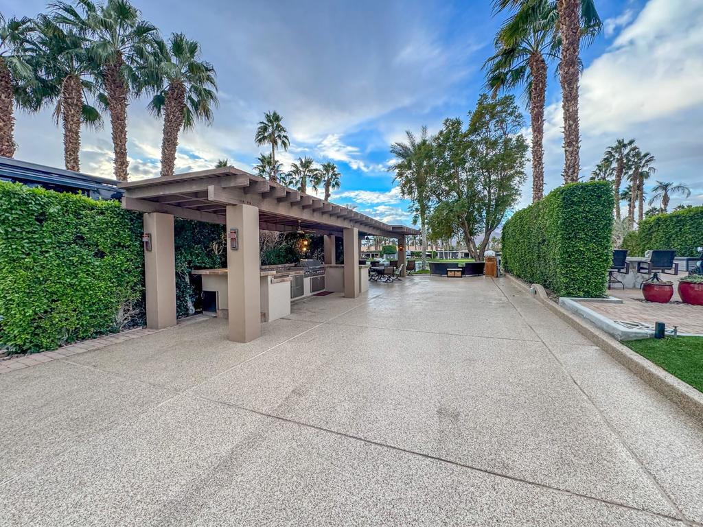 Outdoor Resort Indio is a class-A only motorcoach community. Nestled in one of the most tranquil sections of the golf course, this north-facing luxury RV lot offers stunning mountain views both front and back, with the 11th hole tee-off right at your doorstep. The long pergola, freshly repainted last year, provides ample shade, ensuring your RV, car, and golf cart stay cool throughout the day. Enjoy the breathtaking afternoon mountain sunset views while relaxing under the pergola, cooled by two fans and surrounded by private hedges that enhance the lot's seclusion. The resurfaced RV pad, extended with pavers, accommodates a 45-footer with room to spare for additional parking, while dual hookups at both ends and the middle add unparalleled convenience.The outdoor kitchen is a chef's dream, featuring a large backsplash, built-in bar, stainless steel cabinets, a dishwasher, a small refrigerator, and a built-in BBQ. Landscaped for beauty and privacy, this well-maintained lot is fully furnished with high-end Tropitone furniture for a touch of elegance. With no stray golf balls to worry about, this premium property is also a fantastic income generator, commanding top-tier rental fees. Offering cool comfort, stunning vistas, and unmatched privacy, this unique lot is a rare find in a serene and desirable location.