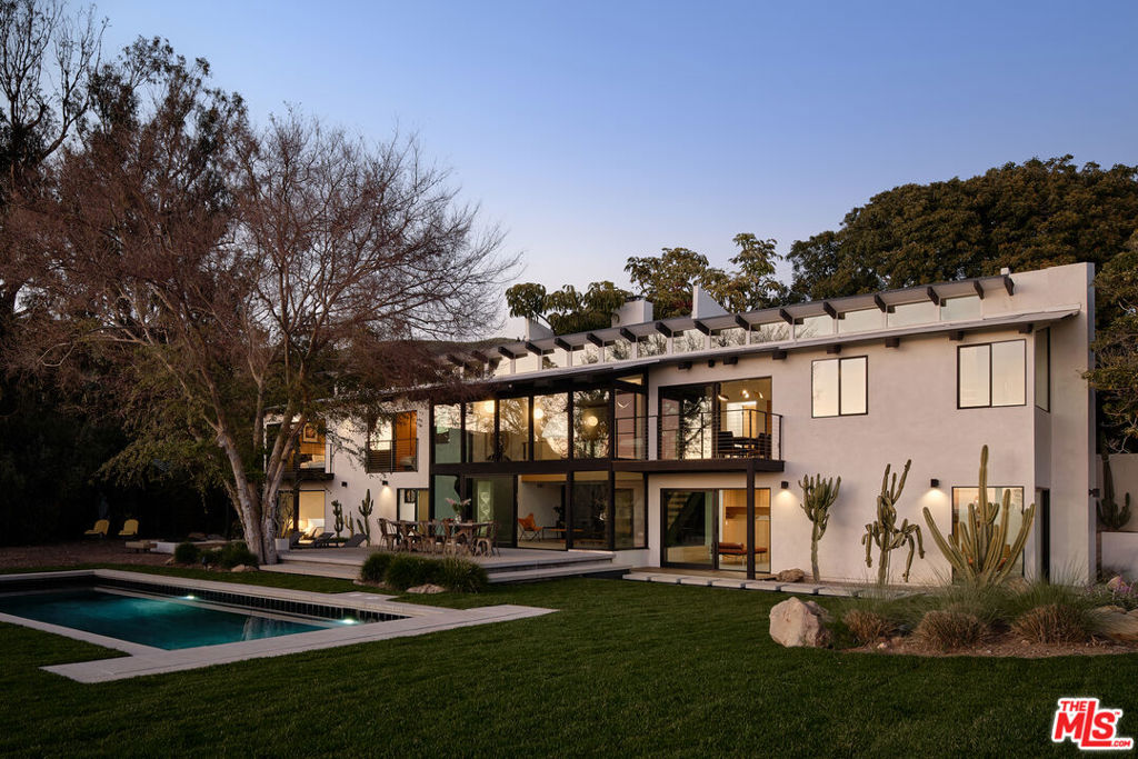 Restored, reenvisioned, and celebrated as one of Edward Fickett's most remarkable architectural creations, The Filaree House is thoughtfully situated on over an acre in Malibu Park. While honoring Fickett's midcentury modern vision, the renovation upholds the authenticity of the original details and design. The gated driveway leads to the expansive approach and vestibule, where walls of glass unveil the grandeur of the double-level living room below, offering breathtaking vistas of the blue hues of the Pacific and vibrant sunsets. The main level contains the open-concept chef's kitchen and dining area overlooking the grassy lawn, shimmering pool, and paddle tennis court. A corridor of original beams leads to the primary suite with a sanctuary-style ensuite and an enchanting private meditation garden, fostering a sense of tranquility and serenity. Accompanying this level are two additional bedrooms, each complete with its ensuite bath. The staircase leads down to the living room, featuring a wood-burning fireplace, and an adjoining family room extending seamlessly to the vast grounds, creating an inviting space for relaxation and gatherings. This level also includes a stylish study and an additional primary suite. Completing the estate is a secondary A-frame structure that offers versatile space for an office or gym, while a renovated Airstream nestles below on one of the terraces. An iconic Malibu midcentury modern masterpiece, The Filaree House blends the timeless design of yesteryear with modern luxury.