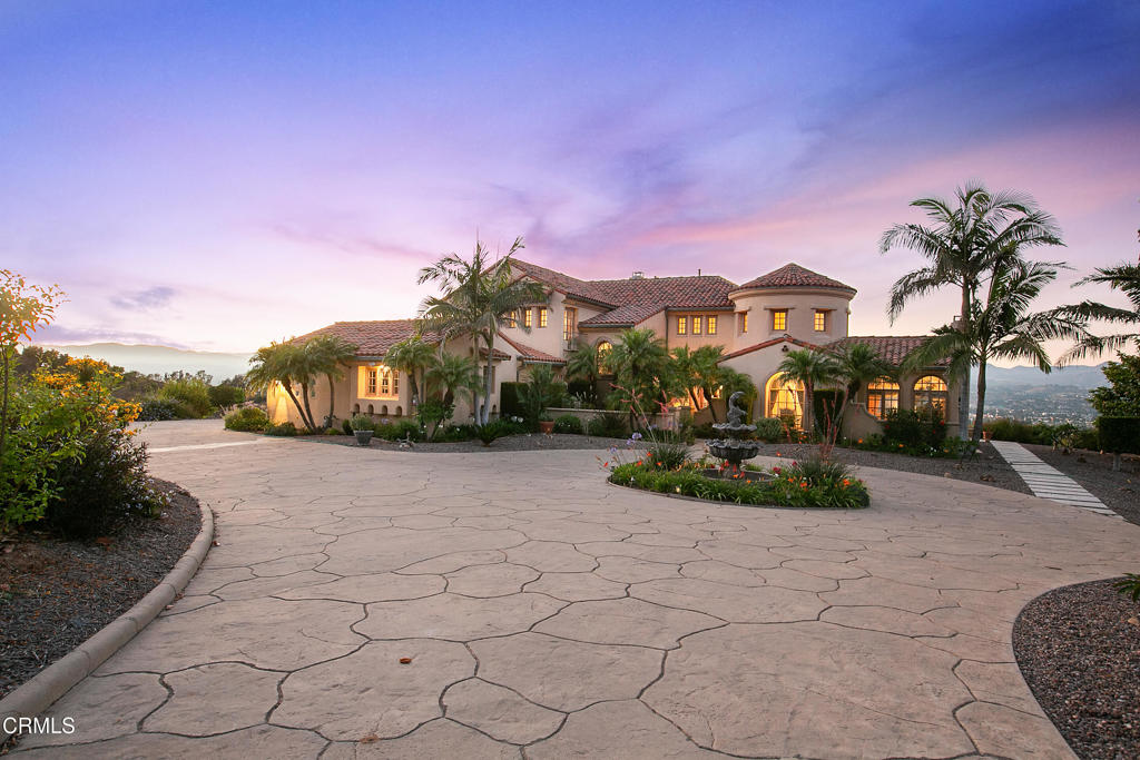 ON A CLEAR DAY YOU CAN SEE FOREVER. Majestic Tuscan-Inspired Estate with 180 Panoramic Mountain Views. Set behind a long, private driveway in the heart of Santa Rosa Valley, this Tuscan-inspired estate combines timeless design with impeccable quality and breathtaking snowcapped mountain vistas. A circular motor court anchored by a lush garden welcomes you to this secluded retreat, where elegance meets natural beauty. The home is equipped with a seller-owned solar system and back-up battery, ensuring energy efficiency and peace of mind.Enter through a beautifully landscaped garden courtyard and fountain into a dramatic 25-foot-high rotunda foyer. The adjacent step-down living room is designed for sophisticated entertaining, featuring a fully equipped wet bar, expansive mountain views, and French doors that open to the East yard. The formal dining room flows seamlessly to the butler's pantry, breakfast area, and chef's gourmet island kitchen, while the family room offers a cozy fireplace, media center, and direct access to the rear yard's spectacular scenery.A handsome library or private office with its own wet bar and courtyard access provides a tranquil workspace. Wine lovers will enjoy the dedicated wine closet with bonus storage. Ideal for guests or staff, the main level includes a private bedroom with en-suite bath, walk-in closet, and access to a separate parking area. Additional features include an indoor laundry room and generous utility space.Upstairs, the primary suite is a peaceful sanctuary complete with fireplace, sweeping views, a spacious walk-in closet, and a versatile retreat ideal for a home office, gym, or lounge. The spa-like bathroom offers a Jacuzzi tub, dual-head shower, and veranda access that overlooks the serene natural setting. All secondary bedrooms include walk-in closets for optimal comfort and privacy.The expansive grounds boast an income-producing avocado orchard with 375 HASS avocado trees, along with nearly 100 exotic fruit trees, including American Wonderful pomegranates, Persian sour cherries, Persian sweet lemons, quince, tangerines, figs in three varieties, Persian sour oranges, Persian king berries, Asian pears, Valencia oranges, and Cara Cara oranges.This exceptional estate offers the perfect blend of luxury, privacy, and sustainable living.