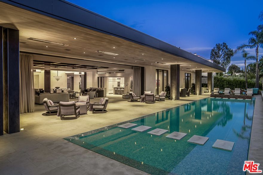 Over $42mm invested. Priced $10mm under comps. The best buy in Beverly Hills. Over 13,000 square feet on over an acre in lower Trousdale, featuring a sprawling entry hall leading to a great room with a motorized wall of glass overlooking the outdoor spaces, infinity edge pool, and city lights. An elegant gallery leads to the master suite which offers dual baths, shower garden, massive closets, and fireplace. 5 additional bedroom suites, one of which is a hotel style suite with a separate sitting room and dual closets. Other rooms include a professional THX 3 tiered screening room and indoor and outdoor catering kitchens.  The home was designed to showcase art with museum style tracks and lighting. Spectacular grounds with one of the largest flat lawns in Trousdale. With all of this comes approved plans for a 3600 square foot two story guest house the only of its kind permitted in Trousdale. Complete privacy behind gates and a security guard house. A Trousdale Showplace!
