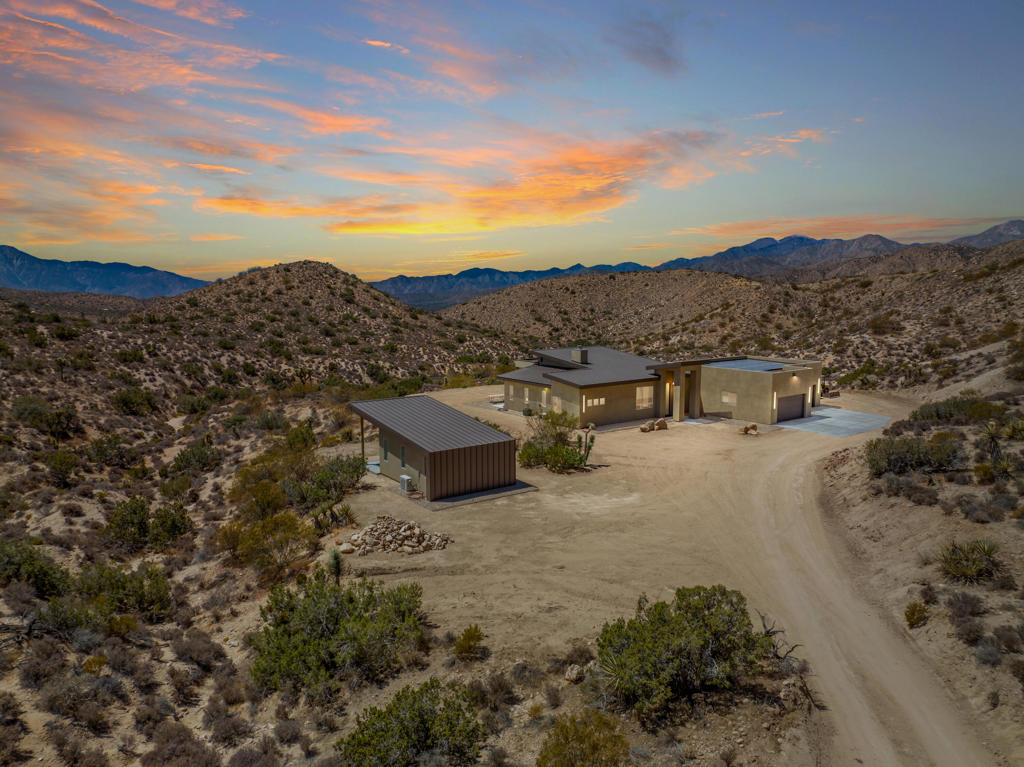This 52 acre 2022 custom built Estate may showcase the most superior 180 degree views that the Joshua Tree, Yucca Valley JT National park area has ever seen! Located close the JT National Park Black Rock entrance you will enter through a private security gate onto a 1000ft driveway that takes you down to this ultimate privacy and unrivaled views incredible custom home and property! This custom built solar home was designed to keep these one of kind views in your line of sight from just about everywhere in the main house and detached art/ guest house. The back of this home is open to these views as far as you can see, and you will own all that land in front of you with no neighbors making the privacy truly magical and rare.When you enter the main home you will be greeted by 12 foot ceilings, and exposed concrete aggregate sealed floors.Gourmet kitchen features luxury sub zero &kitchen aid appliances and island and separate coffee bar to mention a few upgrades! Thirsty? Walk into to the 756 bottle refrigerated wine room. Enjoy that glass of wine with glass pocket doors open and hidden to the fresh air and patio for entertaining, This fully owned solar smart home also has a detached art studio/guest house and the 4 car garage is over 1200 sq ft! The possibilities are endless here on 54 acres with walking trails room for a pool, horses, a yoga or large events venue?? Owners recently hosted a 150ppl wedding! Vacation rental income could be sky high. Hurry on this one!