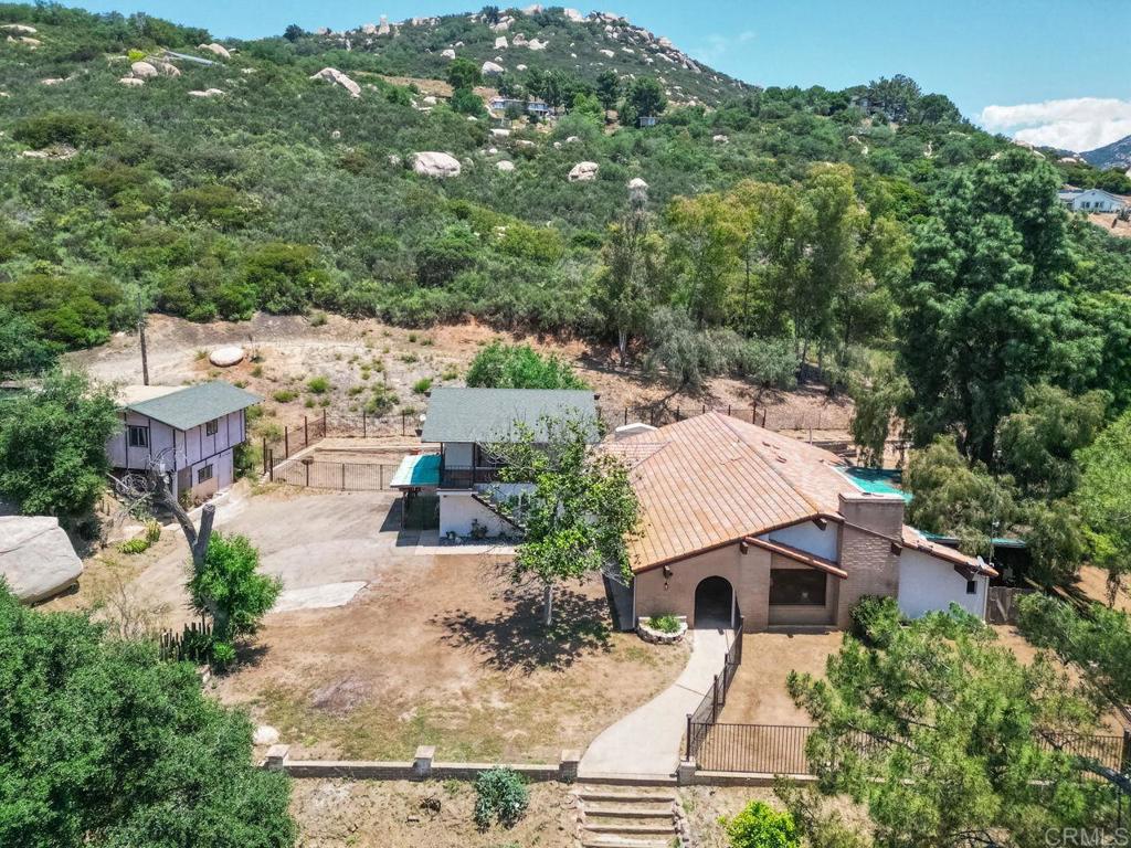 Charming Spanish-style home on 13+ scenic acres in Jamul. Features include a renovated kitchen, guest quarters, and a large multi-use shop. Enjoy 8 acres of flat, usable pasture perfect for horses, farming, developing or recreation, plus over 5 acres with the main home, guest quarters, and a large multi-use shop. A seasonal creek & pond, multiple wells, and two electric meters add to the property’s appeal. Bring your vision and make it your own with the endless possibilities! Property is zoned A-72 with a "0" designation for animals.