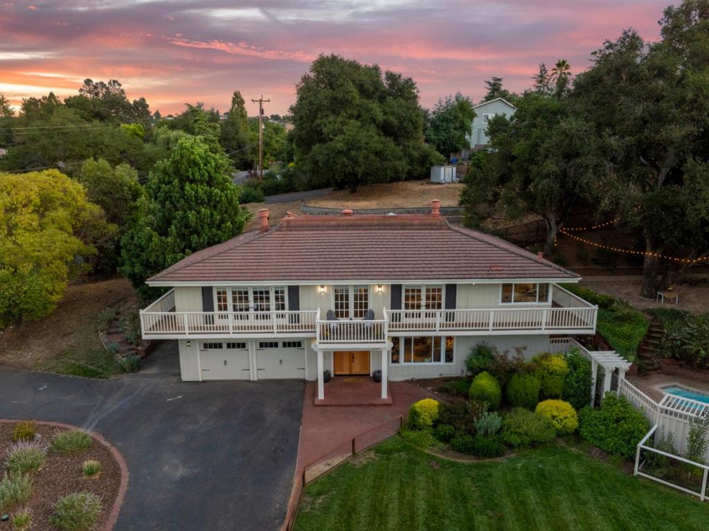 Nestled in the highly desirable Holiday Lake Estates of Morgan Hill, this spacious 5-bedroom, 3-bath home offers over 3,000 sq. ft. of living space on a generous 0.62-acre lot. Designed with both comfort and entertaining in mind, the open floor plan features multiple gathering areas, a bright modern kitchen, and expansive windows that frame hillside views while flooding the home with natural light. This custom home includes a kitchen/dining area with a fireplace, creating a warm and inviting atmosphere for family meals and gatherings, wrap around porch, and historical elements, such as a staircase railing from an 1800s mansion in San Francisco. The versatile downstairs suitewith its own bedroom, bathroom, and living roomprovides a perfect setup for a nanny, multigenerational living, or a private hangout for kids and guests. Step outside to your own backyard retreat. A sparkling pool and soothing hot tub make summer days and starlit evenings equally inviting, while mature landscaping ensures privacy. The expansive patio offers plenty of space for outdoor dining, play, and relaxation