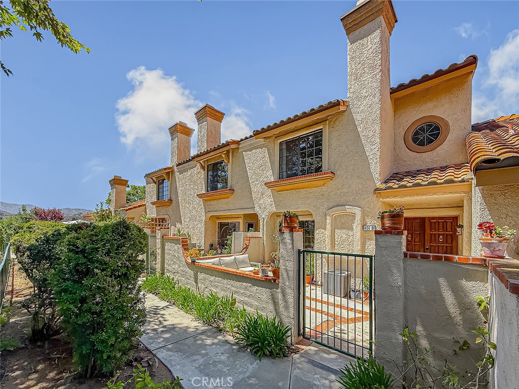 Charming Wood Ranch townhome in the desirable Marlborough Villas II community, just steps from Wood Ranch Golf Course, boutique shops, dining, hiking trails, and less than 5 minutes to the renowned Ronald Reagan Presidential Library. This beautifully updated 2-bedroom, 2.5-bath home features new laminate wood-like flooring, soft designer paint tones, and an open layout. The inviting living room with recessed lighting and a cozy fireplace flows to the dining area and private atrium, perfect for relaxing or gardening. The bright kitchen offers crisp white cabinetry, sleek black appliances, a large garden window, and direct access to the attached two-car garage with laundry area. A stylish powder room and mirrored wet bar complete the first floor. Upstairs boasts two spacious en-suite bedrooms, including a primary suite with treetop views, dual sinks, walk-in closet, and arched entrance, plus a second suite with high ceilings and a private bath. Additional highlights include a private front patio, custom linen storage, central air and heat, and resort-style community amenities with a pool, spa, and greenbelts. Move-in ready and ideally located, this home blends comfort, style, and convenience