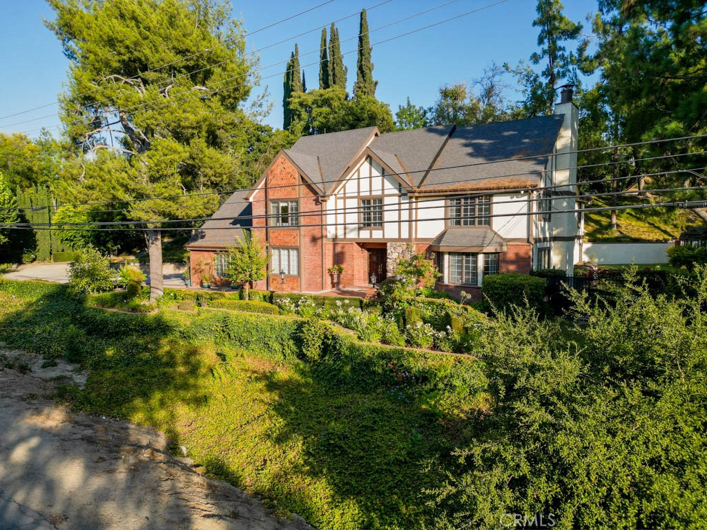 Located in one of Covina Hills sought after neighborhoods, this stately English Tudor home offers generously sized living spaces and beautiful maintained grounds. Inside you'll find a formal living room, a separate dining room with a magnificent crystal chandelier and a bright, spacious kitchen equipped with granite counters, built-in appliances, such as a 6 burner WOLF range and a breakfast island. The adjoining family room is designed for entertainment and comfort. There is a grand bar with bar stools and French doors that open to a private covered patio. Upstairs, the primary suite is a standout with a corner fireplace, walk-in closet, and an oversized bathroom with an luxurious tub and views of the back yard. There are 3 additional bedrooms and a bonus room.
Set on an oversized lot, the property includes mature landscaping and tall trees. Additional highlights include newer roof, alarm system, large attic, and ample parking.
Come and see this property!