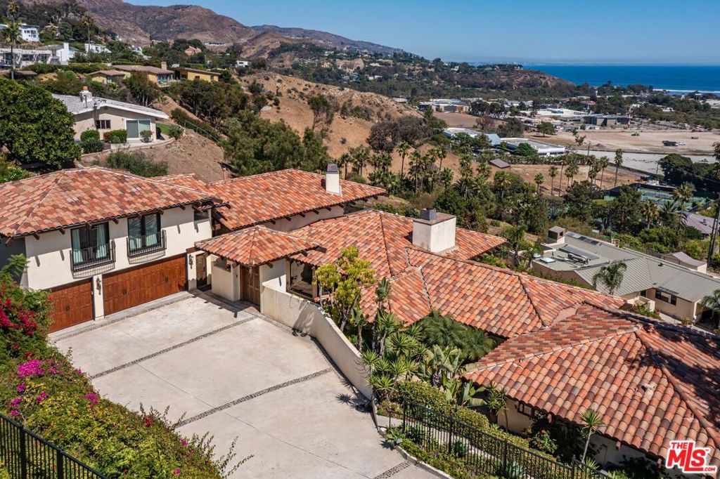 Located in in the heart of Malibu overlooking the Malibu Colony Plaza, Cross Creek and Surfrider Beach, this Spanish Contemporary residence is ideally situated in one of Malibu's most coveted ocean view neighborhoods, offering convenient access to local amenities, premier shopping, world-class dining, and iconic beaches. Boasting 5 bedrooms and 5 bathrooms, this expansive home encompasses nearly 5,000 square feet of sophisticated living space, featuring refined, updated finishes throughout. The open-concept living area flows seamlessly to an outdoor patio and pool, showcasing panoramic views of central Malibu, extending to the Santa Monica Bay and the renowned Queen's Necklace.