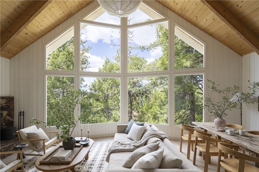 A prow front retreat in the pines. Designed with intention, this 3 bed, 3 bath home blends cozy mountain living with modern comfort. Vaulted ceilings, a wall of glass, and forest views at every turn create that true treehouse feel. As you enter, a charming mudroom sets the tone with checkered tile floors and sage green details, the perfect place to kick off your shoes before stepping inside. The entry level continues with an updated kitchen, dining, and two bedrooms with a full bath. From here, step out to the expansive deck for coffee in the morning or an evening by the fire. Upstairs, the prow front living room makes the statement with natural wood ceilings, a wood burning fireplace, and windows that frame the pines. A third bedroom, full bath, and loft complete the space with comfort and character. On the lower level, a family room with fireplace, bonus area, laundry, and another full bath make for easy living. Step outside to the patio where a hot tub and string lights set the mood. Lake rights included, with the option to purchase a multislip dock in Meadow Bay for the full lake package. Tucked away in a peaceful setting yet just minutes to everything Lake Arrowhead has to offer.
