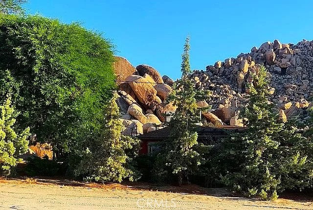 1 and 1/4 acres, corner lot at Mile Square Road and Foothill Drive. Paid water meter, Joshua Basin Water District. The property lies 1,240 feet from Joshua Tree National Park and the south adjacent property is the world class garden of Villa dei Fiori which can be seen in the photos. . To the north lies Casa Mila, a 3,000 sq. ft. recently built Southwestern colonial style house. The corner lot is basically level, sloping to the north. Bighorn sheep herds come down from the boulders to the property across Foothill, Bobcats, hawks, owls, and foxes live in the rocks, a perfect place to enjoy wildlife.