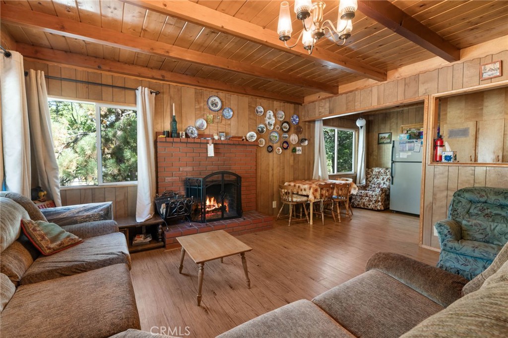 Escape to this charming mountain retreat nestled in the heart of Big Bear, just minutes from the lake, marinas, village, snow play, ski resorts and all that Big Bear has to offer! This super woodsy cabin exudes rustic charm and cozy comfort, featuring a brick fireplace as the centerpiece of the living room, wood beamed ceilings, newer windows that flood the space with natural light while the updated flooring and bathroom add a fresh modern touch. Step outside onto the expansive back deck, perfect for entertaining, relaxing under the stars or simply enjoying the serenity of the mountains. Situated on a generous 12,000 sq st lot, there is ample space to spead out in the alpine ambiance. whether you are looking for a weekend getaway, vacation rental, or full time mountain home, this home delivers the perfect mix of location, character and comfort.