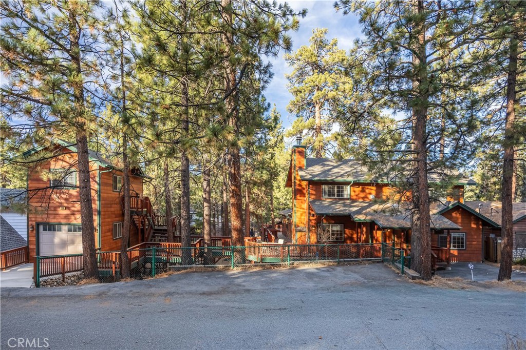 Discover this rare gem in Big Bear! A stunning 2,900 SF custom cabin with guest house situated among beautiful mature pines on a vast 10,000 SF lot. Boasting five spacious bedrooms plus an office that doubles as a sixth bedroom. This meticulously planned retreat offers an open-concept family great room, a gourmet kitchen with granite countertops, a game room with a pool table, and a cozy den with a fireplace. Enjoy two master suites with fireplaces too - one on the main level and another upstairs - each designed for comfort and privacy. There is plenty of storage including spacious walk-in closets & a kitchen pantry. Wired for 7.2 surround sound, the home also features hot water recirculation, interior laundry, low-maintenance Hardie board siding & ample parking. The owners thoughtfully planned & executed the additions & renovations so you could just relax and enjoy! The exterior setting features expansive redwood decking and exterior speakers that set the ambiance for unforgettable gatherings. Play some horseshoes while the kids play on the swing set and explore the spacious grounds. Multiple entertaining areas, both indoors and out, ensure there’s ample space for everyone to appreciate. A charming guest quarter sits above the single-car garage, adding versatility to the property. With beautiful pine surroundings, thoughtful design, and hard-to-find amenities, this Big Bear haven is the perfect place to roam, relax, and entertain. Get this one on your must-see list!