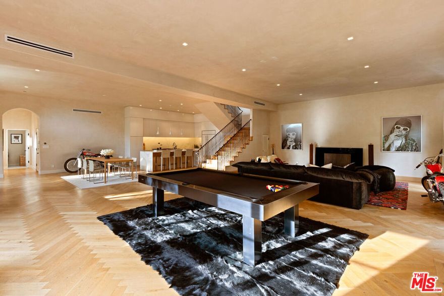 Nestled above the infamous Sunset Strip & Chateau Marmont, lies this ultra-private California Spanish contemporary oasis. As you enter into the private gate, you are welcomed with original brick tiles and lush landscaping, leading you towards the oversized antique wooden front doors. Step inside to experience stunning finishes throughout this 4 bed, 4.5 bath home. Custom Venetian plastered walls continue onto enormous ceilings creating a luxurious environment. Oversized arched windows allow natural light to highlight beautiful details including white oak floors & rich wrought iron fixtures. Main level has an open floor-plan perfect for entertaining. Chef's kitchen is fully equipped with high-end appliances & connects to the formal dining. French doors open to backyard oasis where you can relax by the pool under a trellis-shaded seating area or the upper patio dining terrace. Second level offers 3 ensuite bedrooms surrounding a family room with custom bookcases & 12ft ceilings with a skylight. Some suites connect to a secluded stone patio with a soothing fountain. Fourth bedroom can be used as a permitted rec room, with a separate entrance, equipped with a small kitchenette and full bathroom. Primary & secondary suites open to covered front balconies with airy rooftop & peekaboo views! Recently updated in 2022.