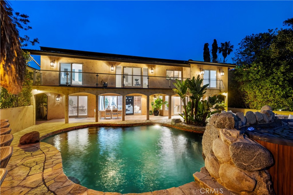 Welcome to 8000 Oceanus, situated in the prestigious Mt Olympus area with city scape VIEWS. Conveniently located on a corner lot, this almost 4,000 square foot home has many stunning custom amenities. As you enter, the formal entry boasts cathedral ceilings, elegant chandeliers, an Onyx stone floor to ceiling fireplace, formal dining with crystal chandelier and a custom wrought iron main staircase. The gourmet kitchen is a chef's dream, complete with top-of-the-line appliances; Subzero refrigerator & Thermador double oven, 6 burner and griddle cooktop, 2 warming drawers, granite counter tops, and an oversized island with ample storage space and wine fridge. The luxurious primary suite offers a peaceful retreat, with a spa en-suite with jetted jacuzzi tub, double sinks and dual walk-in closets. Your private balcony overlooks the serene city scape of Downtown LA. A second staircase off the den provides a separate private suite. The three car garage along allows for an additional 3 car parking in driveway.
Outside, the meticulously landscaped backyard provides an ideal setting for outdoor entertaining and relaxation. Whether you're hosting a gathering or enjoying a quiet evening at home, the outdoor space offers endless possibilities. Enjoy your breathtaking sunrises & sunsets of the unbelievable views from the spa! The Pebble tech pool with waterfall, fireplace, an outdoor kitchen seats 8 and includes all the amenities needed for a proper party. The outdoor kitchen includes a Santa Fe grill, Lynx gas grill, sink, and fridge. There is paid SOLAR included.
This Mount Olympus gem provides the perfect blend of privacy and convenience, being just moments away from the vibrant Sunset Strip, world-class dining, and entertainment. With its unparalleled views, this home offers the epitome of luxurious Los Angeles living. Easy access to everything the city of Los Angeles has to offer. This is your opportunity to find your place in the world where Love -is- Unlimited.