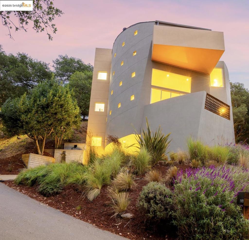 Open Sun Oct 5 1-4pm! Designed by architect Michael Pearce in 1999, this striking 3 bed/2.5 bath Montclair Hills home offers 2,822 sq ft of living space on a 6,534 sq ft lot. Walls of glass showcase sweeping iconic and dramatic views of San Francisco, the Bay Bridge, and the Golden Gate. With curves of concrete; custom wood and stone details, & radiant concrete floors, the dramatic main level features a sunken living room, elevated dining area, spacious deck, and a luxury kitchen with abundant workspace and additional eat-in/bonus area. Upstairs, the one-of-a-kind skylight hall way ushers you to the primary bedroom with deck and a spa-inspired en suite bathroom with a secondary private deck access. Two additional bedrooms each with outdoor private access and second full bathroom complement this level. On street level, there is an attached two car garage with interior access. Outdoor living shines with multiple decks, a grassy terrace for sunset views, a concrete custom waterfall feature in front, and drought-tolerant landscaping. This home is unique in all of the best ways; and lends itself to relaxation, entertaining and hosting, all while being in the classic Montclair Hills - close to Montclair Village, Rockridge BART/shopping, hwy 13/24, and amazing trails and hiking!
