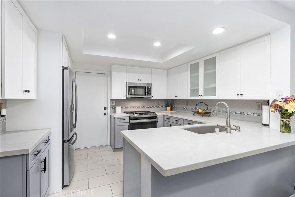 Perched atop the serene hills of the sought-after Amber Lane neighborhood, this beautifully upgraded residence offers the perfect blend of comfort, style, and location. Nestled near the end of a quiet cul-de-sac in an intimate, well-maintained community of just 23 homes, this rare gem boasts a thoughtfully designed layout with three bedrooms and three bathrooms. TWO SPACIOUS PRIMARY SUITES upstairs, each with a private bathroom & walk-in closet, and a convenient DOWNSTAIRS BEDROOM with an adjacent full bath. Step into a light-filled living room with vaulted ceilings, creating an open, airy atmosphere perfect for entertaining or relaxing. The private, secluded, nice-sized backyard, bordered by mature hillside trees, offers a peaceful escape complete with a relaxing above-ground hot tub included in the sale! Car enthusiasts and storage lovers will appreciate the ATTACHED THREE-CAR GARAGE, a rare find in the area. There is also an opportunity to add a fourth bedroom or office within the footprint of the house on the second floor (attic space over the garage). Recent UPGRADES INCLUDE: Fully remodeled kitchen (2020) featuring “marble-like” quartz countertops, custom tile backsplash, oversized tile flooring, stainless steel GE appliances (gas stove, oven, microwave) LG dishwasher (2023), recessed lighting, glass-insert upper cabinets, and soft-close shaker cabinetry in a stylish two-tone design. Remodeled bathroom upstairs (2021) and downstairs (2023) with elegant walk-in showers, large-format tile, shaker vanities with quartz countertops, rain shower head, modern fixtures, and water-efficient toilets. Hickory wood flooring installed throughout for a warm, timeless look. Updated systems: air conditioning, furnace & ducting replaced (2014), and water heater (2022). Additional features: family room fireplace, Dual pane windows & storage cabinets in the garage. Located between Nohl Ranch Road and the Anaheim Hills Golf Course, easy access to top-rated schools, the scenic Oak Canyon Nature Center, numerous parks & hiking trails, shopping, dining, entertainment and close proximity to the 91 and 55 freeways. Amber Lane is a charming, single-street community known for its meticulous upkeep. The HOA covers hazard & liability ins. for the structure, exterior maintenance (including roof and front landscaping), and community care giving you peace of mind and a well-kept environment. A truly special home in a quiet, exclusive neighborhood, come experience it for yourself!