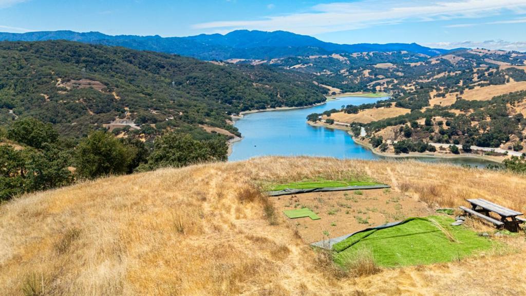 22.79 Acre Private Estate Lot with Panoramic Lake Views Planning Approval in Progress! Elevated above Chesbro Lake w/ breathtaking 360 degree views, this 22-acre property offers unmatched privacy just 12 minutes from downtown Morgan Hill. Two large building pads and a lower pad are ready for your dream home. A recorded access easement is already secured saving you years of legal work and six figures in development costs. Major permitting already in progress with planning comments addressed. Included: site SOP, soils, geotech, engineered road plans, arborist report, approved septic plan, and conceptual home design. Shared well with clean, abundant water, and power/internet scheduled by neighboring parcel in 2025. Site roads are graded and usable w/ more improvements underway. Perfect for a luxury estate, off-grid retreat, or nature escape. Rich wildlife, fertile soil, and lake access create an ideal setting for recreation, gardening, or simply unplugging. This is not just raw land it's a head start on something extraordinary. Access road to the lot will be paved and utilities (power, water, and internet) will be pulled right to the edge of the lot. It will need to be extended to the homesite by the new buyer. Main Access is through Woodland, and dirt road down to the Lake w/gate