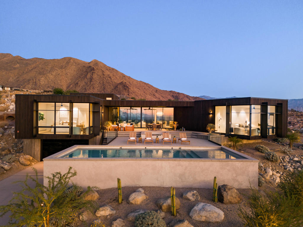 Welcome to the exclusive Desert Palisades enclave in Palm Springs, where world-renowned architects collaborate to create sustainable, cutting-edge homes. Embrace 360-degree mountain views with this newly constructed, architectural gem, surrounded by boulders and nestled in the hills at the base of the San Jacinto Mountains. Nearly 3800 sq.ft. of luxurious living space offering seamless indoor-outdoor living, a spacious open floor plan including living room and dining area, an expansive deck, meticulous landscaping, and a luxurious pool. As you enter the residence, clad in Japanese Sugi Ban wood, you are greeted with phenomenal mountain, desert and city views through floor to ceiling Monumental sliding glass doors and windows. The clear wood oak floors accent the hot rolled steel two-sided fireplace that extends from the living room to the family room/den. The gourmet Chef's kitchen is outfitted with top-of-the-line Miele appliances, two dishwashers, wine refrigerator, Hans Grohe fixtures, Blanco farmhouse-style sink, designer lighting and European-style cabinetry. The primary bedroom suite is an opulent retreat, complete with sliding door access to the outdoor patio, pool & spa, a glass-enclosed shower, luxurious free-standing soaking tub, a hallway of expansive custom closets and its own stackable washer/dryer. There are two lovely, well-appointed guest bedrooms, each with uniquely designed en-suite bathrooms providing their own spectacular mountain and city views. Each bathroom includes beautiful walk-in showers, Robern lighted medicine cabinets, in-wall tank Toto toilets, and ample closet space. Other home features include Eastern European wood interior doors, seven skylights (2 being operable), Kohler bathroom sinks, under cabinet lighting, separate laundry/utility room, 6 state-of-the-art security cameras, owned solar for energy efficiency, 5 HVAC zones and a huge 980 sq. ft. garage to accommodate both vehicle and storage needs. The expansive outdoor space is an entertainer's dream featuring a built-in firepit and gorgeous custom Pebble-Tec pool with tanning shelf and separate raised spa. The spectacular 360-degree views enhance the beauty and serenity of this home's outdoor living. Surrounded by mountains, this home's design blends seamlessly with the desert landscape, embodying the architectural ethos of the Desert Palisades. Every aspect of this home has been meticulously curated to fashion an exquisite masterpiece of artful living!