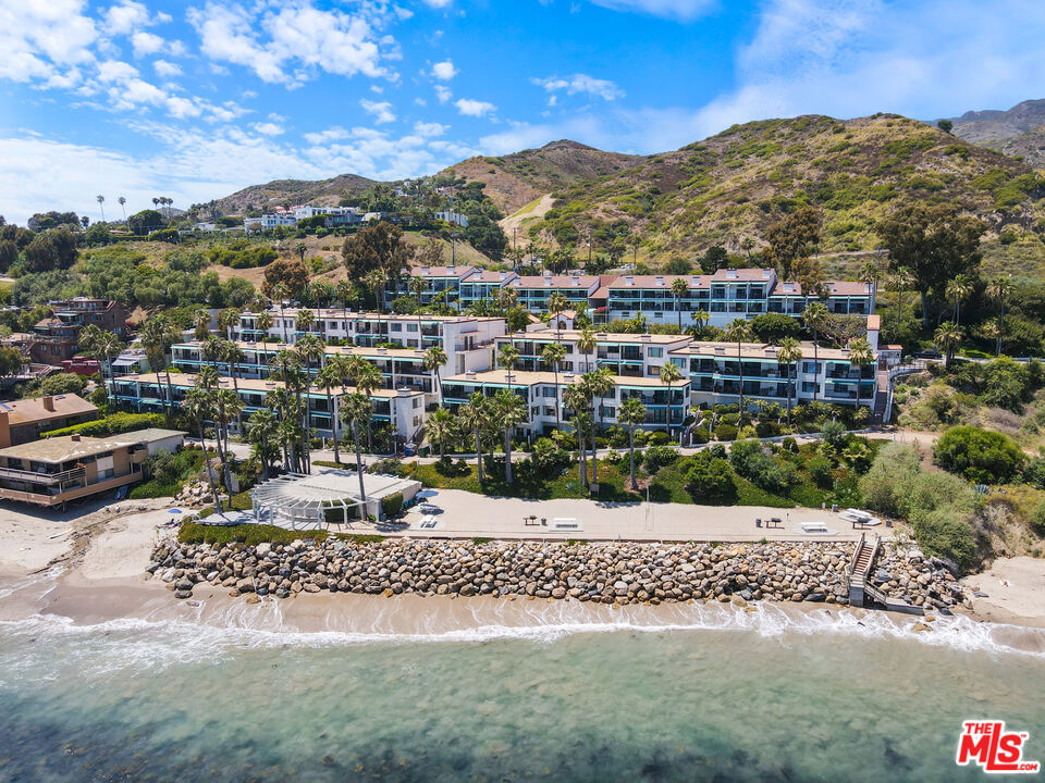 Enjoy resort-style living at the secluded sandy beach of Latigo Shore in this designer home. This beautifully renovated 1 bedroom condo has a large balcony and ocean views. Steps to the ocean and to one of the most beautiful and protected coves in Malibu! The spacious living room with gas fireplace, ocean views and recessed lights opens to the chef's kitchen with top-of-line appliances, custom cabinetry, and an eat-in banquet. Beautifully renovated bathroom features an abundance of storage. Bedroom has stylish built ins, ample closet space, and area for home office. Relax to the sound of waves and the ocean breezes on your private patio overlooking the water. Tivoli Cove amenities include gated entry, pool, spa, gym, sauna, clubhouse, 2 tennis courts, BBQ, volleyball court, and great surf spot. This home includes a large storage room near unit and one indoor and one outdoor parking space (2 total). The perfect way to feel like you're on vacation all year long.