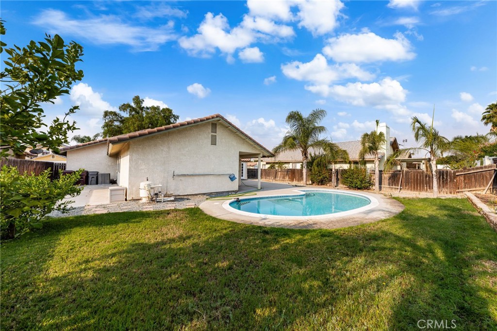 Single story four bedroom pool house with an attached two car garage and fenced yard located between the 60 and 215 freeways. Set on a quiet, tree lined Street, you approach this turnkey home and are greeted by a gated access. Enter via the attached two car garage into a spacious living room with vaulted ceilings. The dining area off the kitchen features direct access to the private yard, which can also be accessed via the primary suite with it's own private bathroom. A second bathroom services the three additional bedrooms. Convenient location, less than five minutes to Starbucks and grocery stores.
