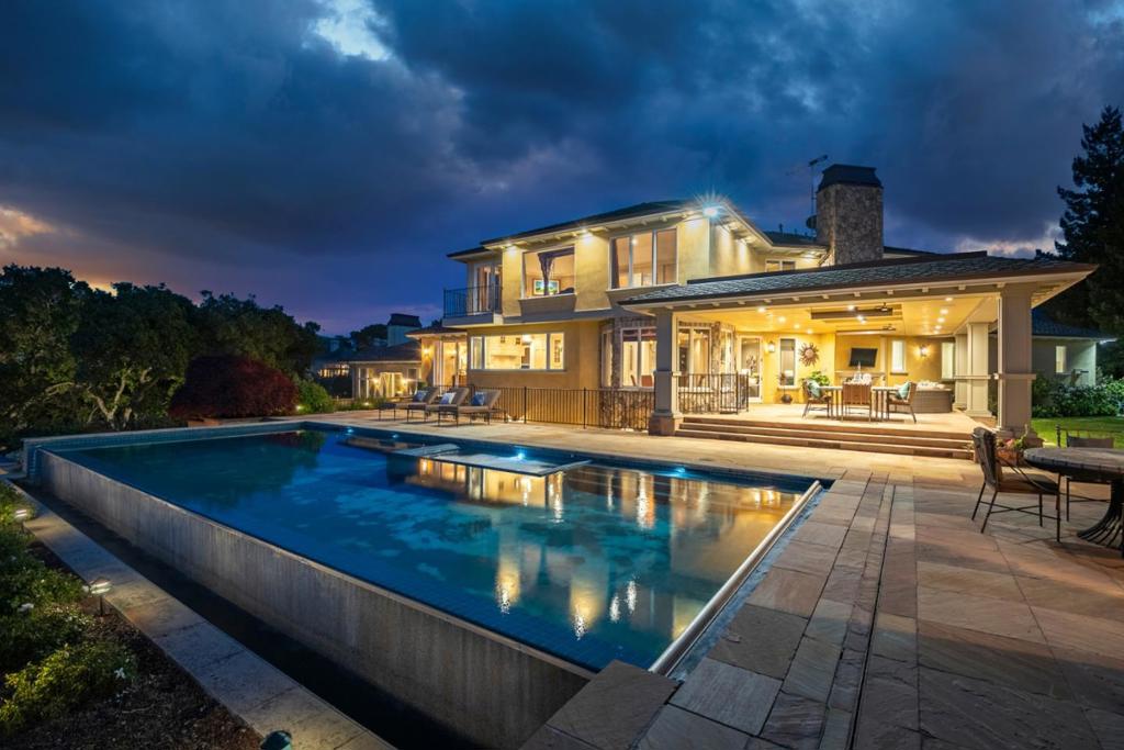 Newly remodeled in 2017, this luxury estate boasts mesmerizing, panoramic views of Silicon Valley & is nestled atop 1.25 ac of lushly landscaped grounds w/private Syrah producing vineyard, mature trees & lovely gardens. Elegant home offers modern amenities, luxurious comfort, & an indoor/outdoor lifestyle. Gracious rooms, soaring ceilings, floor-to-ceiling windows, custom paint & millwork plus distressed oak hardwood & limestone flooring from France. Grand formal entry, formal LR, casual & formal dining rooms, gourmet kitchen, primary bedroom & library. Added in 2017, the extraordinary 1,800 SF lower level w/amazing bar/entertainment area, expansive bonus room & full bath w/space for gym, temperature controlled wine cellar/tasting room & movie theater. Access outdoors to covered terrace & path to pool & hiking trails. Infinity pool w/spa, bocce ball court, outdoor kitchen, wood burning pizza oven, in-ground trampoline & multiple patios & terraces. Minutes to downtown Los Gatos