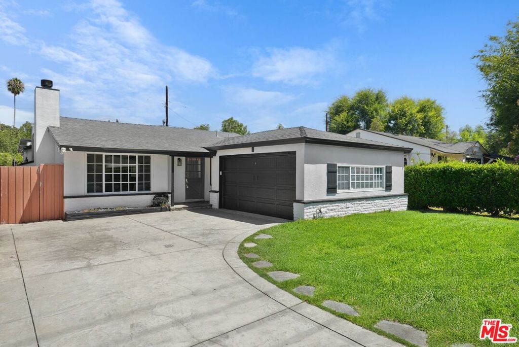 Located just steps from the vibrant shops and restaurants of Ventura Boulevard, this charming single-story ranch blends modern updates with classic character. The spacious living room welcomes you with a cozy wood-burning fireplace and seamlessly flows into a warm, country-style kitchen featuring stainless steel appliances, a walk-in pantry, and an inviting dining area. The private primary suite offers a renovated bathroom and generous closet space, while three additional bedrooms - one with a skylight - share a stylishly updated full bath. Designed for entertaining, the backyard is a true retreat, surrounded by mature privacy hedges and highlighted by a stone patio and a stunning lap pool and spa with a cascading waterfall feature. Additional features include exposed wood-beamed ceilings that add architectural charm, ceiling fans in all bedrooms for year-round comfort, a convenient laundry closet, and a two-car garage equipped with an electric vehicle charging adapter. This move-in-ready gem perfectly combines comfort, style, and convenience in one of Woodland Hills' most desirable neighborhoods.