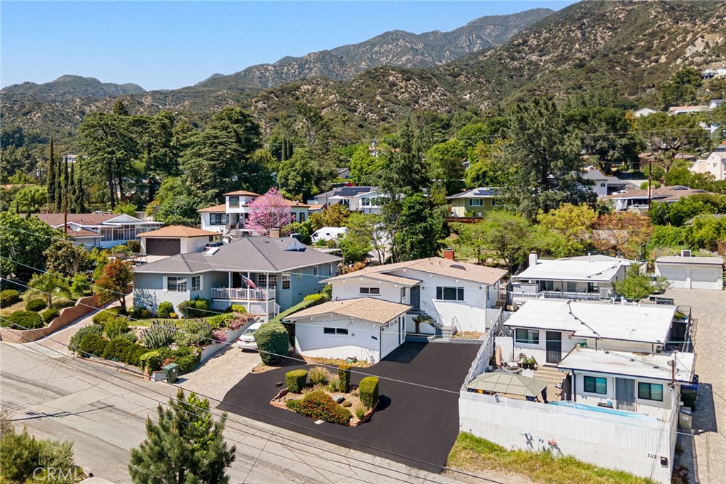 Nestled in one of La Crescenta’s most desirable neighborhoods, this charming 3-bedroom, 2-bath home offers approximately 1,709 sq. ft. of well-designed living space on a generous 9,650 sq. ft. lot.
Inside, natural light fills the welcoming living room, while vaulted ceilings throughout the home create an open, airy feel. The dining area is anchored by a cozy fireplace, complemented by spacious bedrooms, central air conditioning, and a versatile sunroom/laundry room that adds flexibility to the floor plan.
A circular driveway provides ample parking, while the attached 2-car garage has been thoughtfully converted into a studio-style space with its own bathroom and kitchenette—adding roughly 500 sq. ft. of additional living area (not included in the main square footage).
Step into the expansive backyard and enjoy serene mountain views. With room for entertaining, play, or even the possibility of adding a pool, the outdoor space is full of potential.
Located within a highly rated school district, this property presents a rare opportunity to create your dream home in a sought-after community. Don’t miss it!