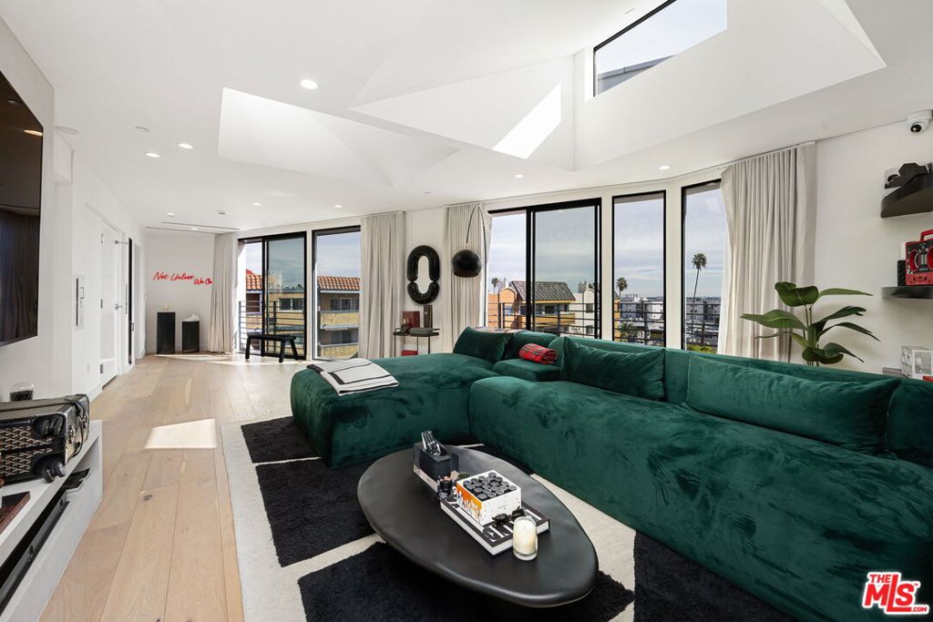 Penthouse perfection. This architecturally distinguished residence crowns the building and commands sweeping city and hillside views. A private elevator opens directly into the home, creating an immediate sense of discretion and arrival. A sculptural spiral staircase leads to an expansive rooftop deck reserved for this residence alone, an ideal setting for quiet mornings and evening entertaining under the skyline.Designed by Wil Carson, the interiors blend graceful curves with warm contemporary finishes. European oak floors ground an open living and dining area that flows into a chef kitchen appointed with Calacatta Laza quartz counters and a waterfall island, Thermador appliances, custom white cabinetry, and a wine cooler.The flexible three bedroom plan is currently configured as two bedrooms plus a custom dressing room with extensive closet space and the third bedroom can be restored with ease. The serene primary suite offers generous wardrobes and a well appointed bath. Additional conveniences include in unit washer and dryer, mobile controlled security, and keyless entry for both the front door and the elevator.The building provides true privacy with controlled access that requires a fob for each floor and gated subterranean parking for two cars. From sunrise to sunset the penthouse frames remarkable views and delivers an elevated lifestyle moments from the Sunset Strip.