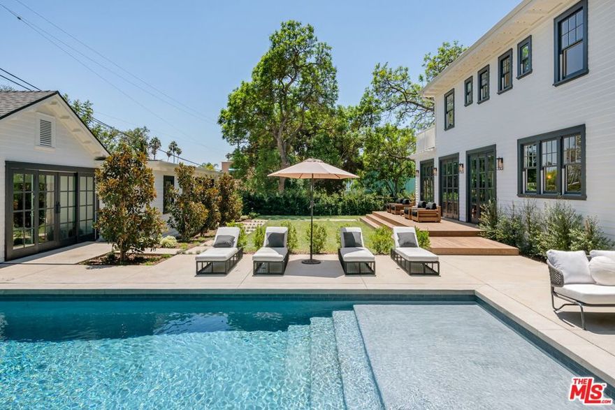 Restored, extensively renovated, walled and gated 1920's Colonial in Sunset Square with 4 bedrooms, 5 baths, and large pool. The property features a formal entry, light oak herringbone floors, custom marble fireplace, large dining room, chef's kitchen with extensive island, premium appliances, double sinks, double dishwashers, and the finest fixtures. A separate breakfast room opens to custom family/media room. A wine chamber is downstairs. Upstairs a dramatic glass and steel atrium leads to 3 bedroom suites including primary suite which expands across the entire south side of the house with private terrace, large custom closet, freestanding and double vanities The outdoor areas are distinctly landscaped, with over-sized pool, outdoor kitchen/BBQ, formal dining area, and spacious play area. And finally a one-bedroom, one bath guest house with fully-equipped designer kitchen. Perfect for a work-from-home office, music studio or creative space.
