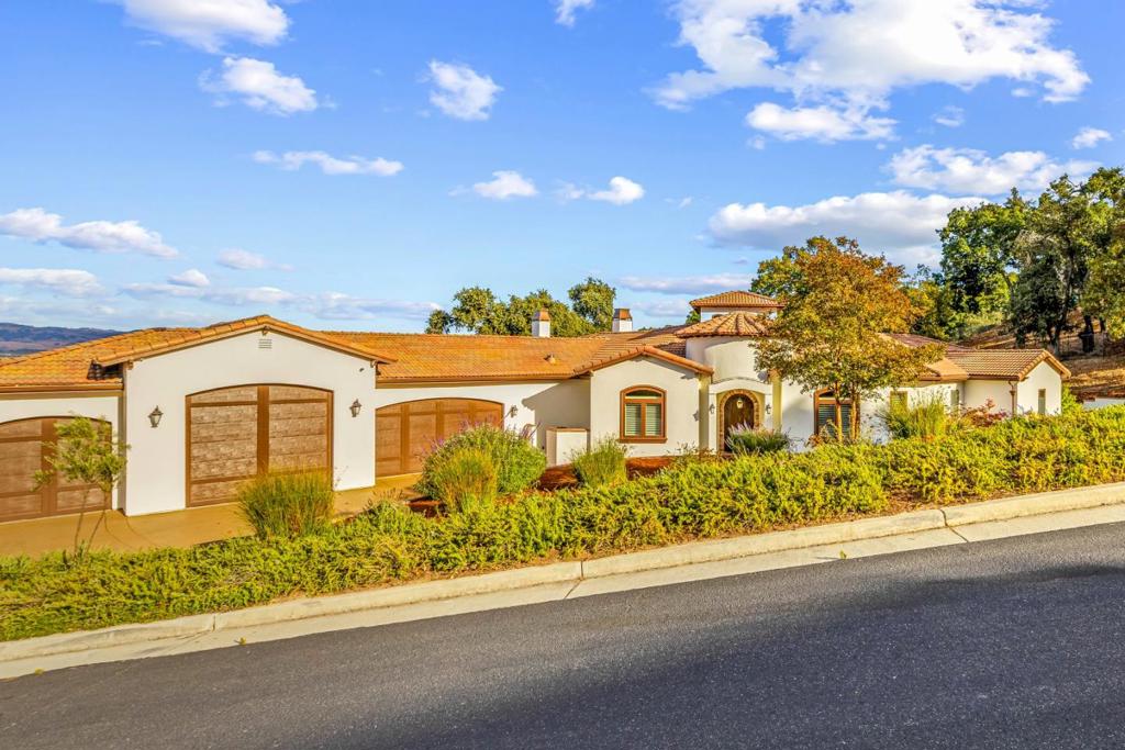 Welcome to an exquisite single-story oasis at 9110 Tea Tree Way, Gilroy, CA. This elegant custom home, completed in 2017, spans 3,641 square feet on over an acre of serene landscape. Enter through epic 20+ foot ceilings that set a grand tone. At the heart of the home is an expansive kitchen with a large island and a premium 6-burner gas range for culinary enthusiasts. Five spacious bedrooms, along with an office, and 3.5 beautifully appointed bathrooms, blend comfort and luxury seamlessly. The west wing of the home features a charming 2-bedroom suite with an adjoining bathroom, offering the perfect retreat for an au pair. A colossal 7-car garage, covering 1,600 square feet, awaits your vehicles or even a boat. Enjoy sustainable living with a 7.5 kW owned solar system, combining eco-friendliness with luxury. Outside, a meticulously crafted backyard with a golf putting surface offers leisurely afternoons. Breathtaking views extend across the surrounding community, offering picturesque glimpses of Gilroy's Valley. Nestled against the majestic west hills, it enjoys a Mediterranean climate with warm summers and mild winters. This home promises an enchanting lifestyle, enriched by nearby vineyards and coastal influences.