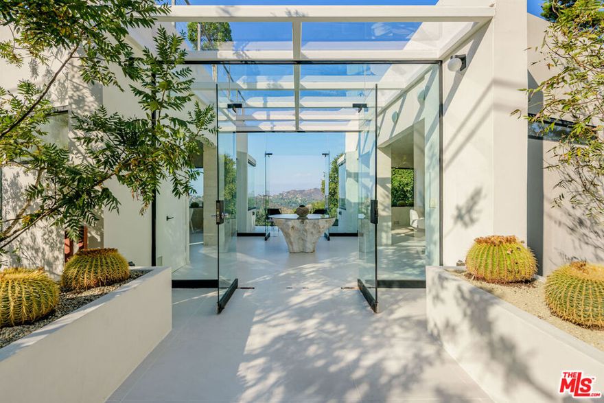 8896 Lookout Mountain Hollywood Hills. A private architectural retreat with unobstructed views of legendary Laurel Canyon. This modern residence combines striking geometric design with natural light, sculpting a home of elegance, privacy, and serenity. The open living space features white porcelain floors, smooth concrete walls, and a statement fireplace, flowing into a chef's kitchen with dark oak cabinetry, porcelain countertops, and top-tier appliances. Two primary suites include spa-inspired bathrooms with Japanese soaking tubs and a shared balcony with an infinity-edge Jacuzzi overlooking the canyon. A third bedroom opens to the deck and landscaped garden. Outdoor living is elevated with expansive decks, a rooftop lounge with panoramic views, and the potential for a leveled garden with secondary street access. Nestled in a coveted enclave of the Hollywood Hills and near acclaimed Wonderland Avenue Elementary, this home offers unmatched privacy and a lifestyle defined by design, views, and exclusivity.