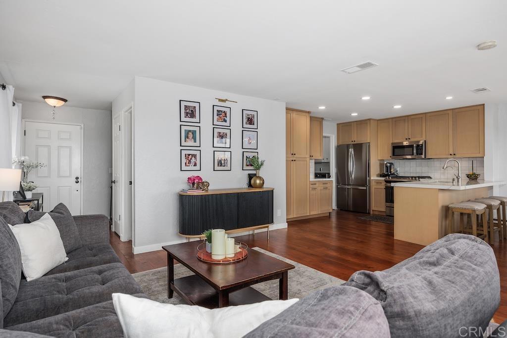 This beautifully updated 1,350 est.sq.ft. end-unit townhome offers 3 bedrooms, 2.5 bathrooms, attached 2-car garage and an unbeatable location on a quiet cul-de-sac in the highly sought-after Meadowridge community. Enjoy sweeping mountain views throughout with multiple sliding doors leading out to the spacious balconies - ideal for morning coffee, sunset dinners, or entertaining guests. The entry-level living space is light and airy, featuring an open-concept great room with crisp white walls, real wood flooring, and a stylish fireplace. The kitchen was fully remodeled in 2024 including the removal of walls to maximize the space and showcases soft-close white oak cabinetry, white countertops, a designer Cloe tile backsplash, and a breakfast bar. The spacious primary suite features sliding glass doors to the patio and a beautifully updated ensuite bath with dual sinks, a wood vanity topped with white countertops, complimenting black accents, and a floor-to-ceiling tiled shower with glass enclosure. One secondary bedroom includes vaulted ceilings, while the other opens to the patio - perfect for a guest room, home office, or flex space. Additional highlights include an attached two-car garage, a private interior laundry room with generous storage, luxury vinyl plank flooring on the lower level, and a reverse osmosis water filtration system. Meadowridge residents enjoy resort-style amenities including two heated pools with spas, two tennis courts, and beautifully maintained open green spaces. All this, just minutes from shopping, dining, golf courses, top-rated San Marcos Unified schools, beaches, and major freeways. Buyer and buyer’s agent to verify all in MLS prior to COE.