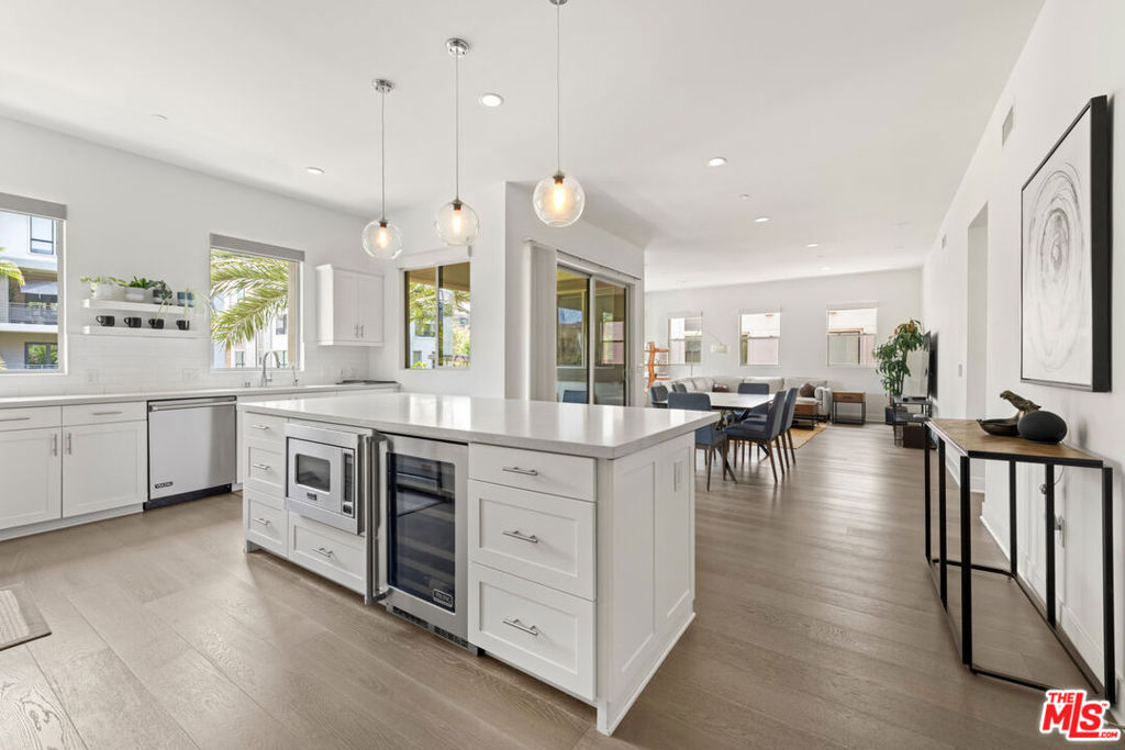 Welcome to this stunning 3-bedroom, 2-bath condominium in the highly desirable Mason community of Playa Vista. Spanning approximately 1,880 square feet, this single-level home offers sophisticated design, modern convenience, and effortless comfort, all meticulously maintained since its 2016 construction. The gourmet kitchen is a true showstopper, featuring VIKING stainless steel appliances, a built-in beverage fridge, double-door pantry, and an oversized island perfect for cooking, entertaining, or gathering with friends and family. Wide-plank hardwood floors run throughout the living spaces, while soaring ceilings, recessed lighting, and large windows flood the home with natural light. Smart home features are seamlessly integrated, including automated window shades, Nest thermostat and smoke detectors, Lutron dimmer switches, and a 220V NEMA 14-50 EV charging outlet offering next-level convenience for today's lifestyle. Enjoy the private patio with serene views of The Lawn, ideal for morning coffee or evening relaxation. Additional highlights include an in-unit laundry room and a private, detached two-car garage. Located just moments from the shops, dining, and entertainment at Runway Playa Vista, and with access to resort-style amenities like the pool, spa, and fitness center, this turnkey home offers the best of Westside living. A rare opportunity to own in one of Playa Vista's most sought-after communities.