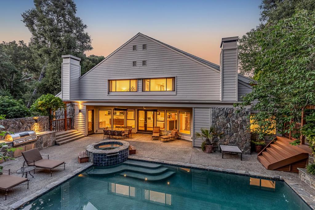 Positioned behind electronic gates at the end of a cul-de-sac with just four other homes, this architecturally significant home offers privacy, scale, & thoughtfully considered living on 1.354 acres. Spanning approximately 5,970 square feet of living space offering ample accommodations. Main level offers beautifully scaled rooms designed for entertaining & everyday comfort, flexible layout for formal living & dining areas, lounge, & a connoisseur's wine cellar with adjoining tasting room. Kitchen is appointed with granite finishes, high-end appliances, & space for casual dining, plus an expansive open family room in the center of the design. Primary suite positioned for optimal light & privacy, dual terraces, sitting area with fireplace, couture closet room, & luxurious en suite bath. An adjoining bedroom provides the ideal space for a nursery/office. Outdoor amenities are equally impressive with a large pool, separate spa, built-in barbecue, prolific rose garden, a protected vegetable garden, fruit trees, & a small vineyard. With two attached 2-car garages, extensive storage, & access to acclaimed Portola Valley schools, this home presents a rare opportunity to own a one-of-a-kind property in an exceptional location.