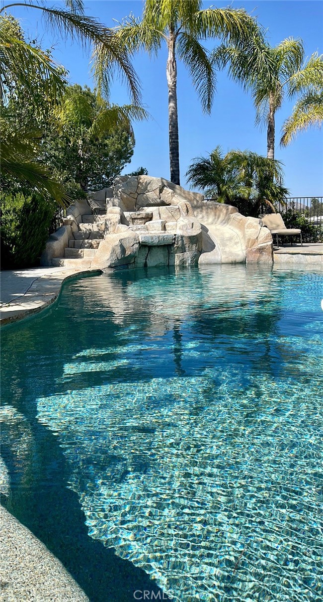 Incredible 3BR/2BA pool/spa home in the heart of the Temecula wine country. This 2640sf home boasts high ceilings with skylights making it bright, open and spacious. Large great room with wood-burning fireplace, formal dining room and dine-in kitchen area. Grand main bedroom suite with custom built walk-in closet and massive soaking tub with dual vanity sinks. Porcelain and vinyl flooring throughout. Incredible tropical heated pool and spa area, fully fenced and beautifully landscaped. Large rear patio/lounge with BBQ island, pool table, made for entertaining. Beautiful, lush lawns in the front and rear yards of this home. Putting green behind pool area and views at every turn. 2-car garage and large driveway.
Please note this home shares a 5.3+ acre parcel with two other separate and relatively private homes, also leased to long-term tenants. See map image at end of photos for layout and see website for virtual videos of property layout and each dwelling.