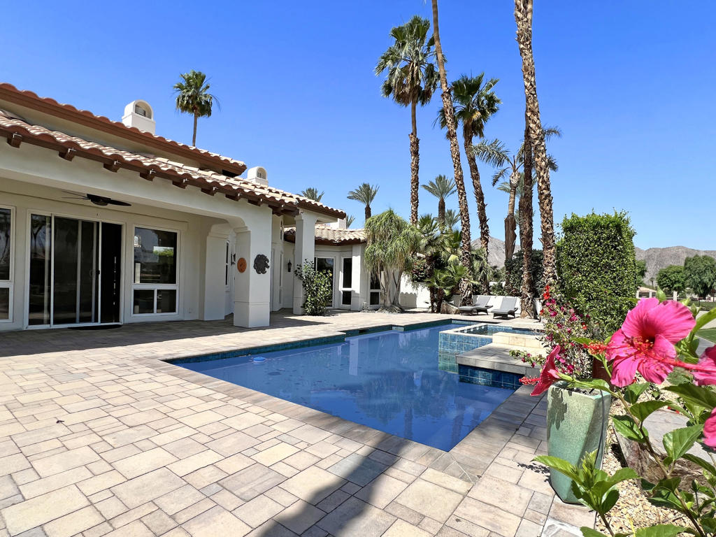 Nestled within prestigious Rancho La Quinta Country Club. Gorgeous modern renovated home with stunning views of the colorful hues of the panoramic Chocolate Mountains & the 9th. fairway of the Robert Trent Jones Jr. Championship Golf Course. Ideally situated on a private cul-de-sac & close to the Club House & all of the amenities. The large backyard entertainer's covered patio features quality stone pavers, custom pool with elevated spa, waterfall & a large built-in BBQ cooking station. This high end PALACIO II mini-estate consists of 4 bedroom, 4.5 baths. A deluxe detached guest house with a romantic fireplace & kitchenette offers guests privacy & comfort. Upon entering the charming courtyard you will be greeted by hand-laid paving stones. Enter the beautiful custom wood glass dual doors and you will be impressed with the craftsmanship & attention to detail. This home has been almost completely retrofitted from top to bottom & has been re-envisioned & modified by removing the wall that separates the kitchen, family room-living room resulting in an amazing open floor plan concept that creates spaciousness with multiple entertainment venues. Features boast updated limestone flooring & plush upgraded carpeting in bedrooms-all bedrooms are ensuite. Modern interior paint colors & modern ceiling fans enhance the ambiance, LED lighting throughout. The newly updated gourmet kitchen is a culinary delight with custom finished cabinetry, Quartz surfaces & beautifully designed contemporary backsplash & top of the line stainless steel appliances. Entertain in style from the step-down wet bar complete with the same luxurious features of the kitchen.The elegant formal dining room with its newly installed modern electric fireplace provides a warm & cozy atmosphere for entertaining. The primary bathroom suite offers Quartz counter tops. a redesigned soaking tub & updated walk-in shower with frameless shower doors. The lavish primary suite with a romantic fireplace opens directly to the pool & spa & offers stunning views of the golf course. HOA dues of $1,198 per month include social membership, use of club house, two other dining facilities, 8 pickleball courts, 9 tennis courts, bocce ball, fitness center, 24 hr. roving security, direct TV, internet, front landscaping & trash. Private membership to 2 golf course is separate. This is resort living at its finest in prestigious Rancho La Quinta Country Club.