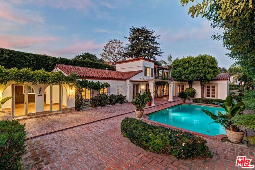 Now Beverly Hills best value in the Westend of the city. 1st time available for sale in 51 years, this utterly romantic 2sty 1927 Spanish Villa is replete with European ambiance and sited just north of Sunset Blvd and west of Benedict Canyon Dr at the northwest corner of prestigious Ridgedale Dr and Chevy Chase Dr on a large, deep, and flat lot. The home features x-high ceilings, wood floors, beams, hand-painted wall coverings, and French doors. Including the primary, there are two large bedroom suites upstairs and 3 bedrooms downstairs (2 staff rooms and a secondary Junior primary suite). Gracious entry foyer leads to grand living and dining rooms as well as a striking beamed ceiling glass-walled gallery hall. Separate paneled family room/library with fireplace and rear office. There is also a big bar/media room downstairs adjacent to the pool area. Many rooms open to the glorious manicured lush grounds with expansive brick patios, pool, formal rose garden with lily pond, and mature hedging. At the rear of the lot sits a tremendously spacious 1sty guest house of nearly 1,800 sq ft with a high beamed-ceiling great room, family/rec room, 1 bedroom, kitchen, laundry room, and 2 baths. Adjacent to the guest house is a gated motorcourt, carport, and one car garage accessed from Bridle Lane in addition to parking in the circular front driveway. There is truly endless potential for a fortunate purchaser to create an iconic and noteworthy estate on a quiet flat Westend Beverly Hills road within moments to all.