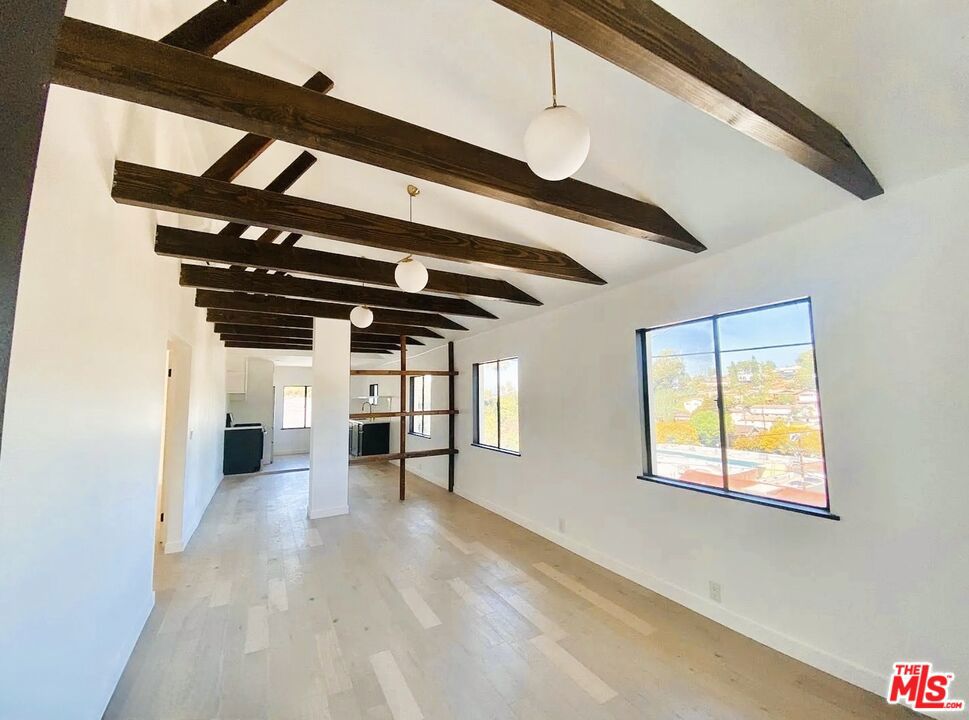 Designer 2BD/2BA Hilltop Retreat in Echo Park w/Sweeping Views, Outdoor Space, Parking & In-Unit Laundry!Welcome to 1520 Marsden Street in Elysian Heights. This beautifully remodeled 2BD second-floor unit in the Echo Park district is full of elevated, modern design touches. Tucked away on a quiet hillside cul-de-sac, with sweeping views of the Eastside hills and a sense of privacy. A private front porch greets you upon entry, before entering a show-stopping living room, where vaulted ceilings, exposed beams, and abundant natural light set the tone. The open floor plan flows effortlessly, highlighted by custom architectural shelving that defines a true dining area. Just beyond, the updated kitchen awaits fully outfitted with stainless steel appliances, including a gas range, fridge, dishwasher, and in-unit stackable washer/dryer. Both bedrooms bring the vibes - one features a walk-through, dressing room-style closet that leads to a luxe en suite bath, while the other offers a spacious walk-in closet and its own full bath just off the hallway. Located in an area you can't beat, just minutes from all your favs: Valerio, Canyon Coffee, Donna's, Lowboys, Short Stop, Echo Plex, Echo Park Lake + so much more.