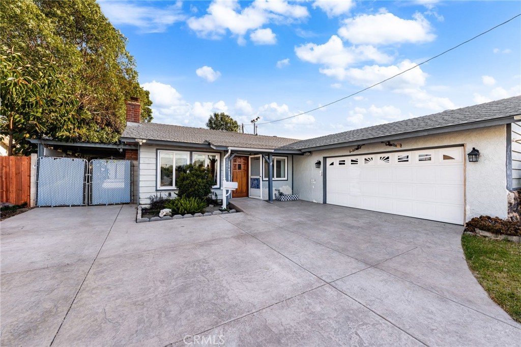 Welcome Home! This charming single-story home demonstrates true pride of ownership! Conveniently located near schools, shopping, and commuter routes, this home blends comfort and functionality. It has been recently renovated and features a spacious floorplan with remodeled bathrooms, updated electrical, and newer hardwood floors. Inside, you’ll find a bright and open living area with large windows, a well-appointed kitchen, and a spacious primary bedroom that offers direct access to the enclosed breezeway/mudroom for added convenience. Enjoy gated covered parking with a paved driveway that extends to the backyard ideal for extra vehicles or storage. The garage is fully drywalled and insulated, complete with built-in cabinets and pull-down attic storage. The backyard is perfect for entertaining or relaxing, with a large covered patio, string lights, and plenty of space to customize. This home is ready for you to make it your own!