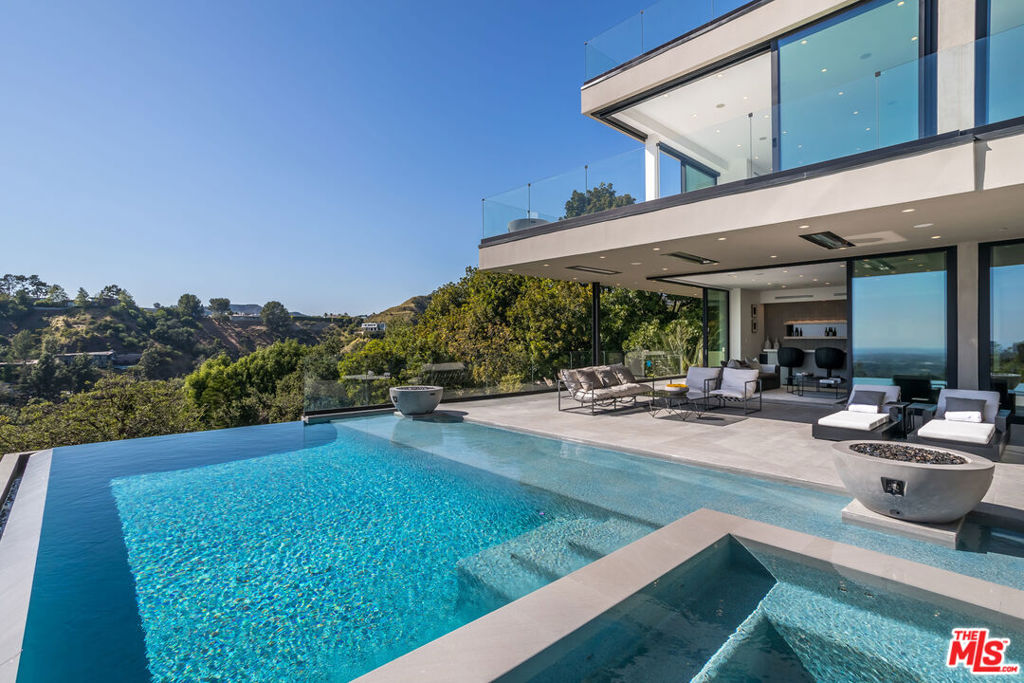 Short-term furnished rental available until the end of September. Located in the prestigious Crest Streets in Beverly Hills, this architectural masterpiece offers unobstructed jetliner views from every room. The new construction smart house features Venetian wall finishes throughout, imported stonework, floor-to-ceiling walls and doors of glass, and over 3,400 sq. ft. of outdoor terraces, creating an unprecedented living experience. The 2,000 sq. ft. primary suite boasts a private glam room, hair salon, 2 garden lounge sitting areas, dual walk-in closets, wet bar, and glass shoe display room. The gourmet kitchen comes replete with a butler kitchen and pantry area. The sophisticated living and dining area is accentuated with a fingerprint-secured Mezcal/Wine tasting room. The lower entertainment level offers a luxurious bar, spa and theatre experience, including a zero-edge pool, Himalayan salt sauna, Japanese soaking tub, private yoga studio/gym, Tonal fitness system, wet steam room, poolside cabana room, and 20 person theater with bar. The private lower grassy yard is surrounded by lush landscaping and includes a large entertainment game space.