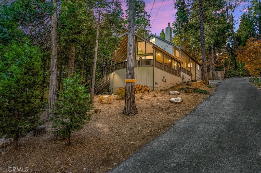Nestled among the towering trees and serene wilderness of Lake Arrowhead, this stunning multi-level home offers the perfect blend of rustic charm and modern comfort. With 3 spacious bedrooms, a cozy loft, and an additional bonus room, there's plenty of space for family, friends, and guests to relax and enjoy the beauty of mountain living. The heart of the home is the open-concept kitchen and dining area, which overlooks the grand living room below. Large windows flood the space with natural light, providing breathtaking views of the surrounding forest and creating a warm, inviting atmosphere—ideal for entertaining or hosting memorable holiday gatherings. Whether you're curled up by the fireplace, exploring the outdoors, or simply enjoying the peaceful ambiance, this home offers a rare opportunity to live among nature while being just minutes away from all the amenities Lake Arrowhead has to offer. Don't miss your chance to own this unique mountain retreat!